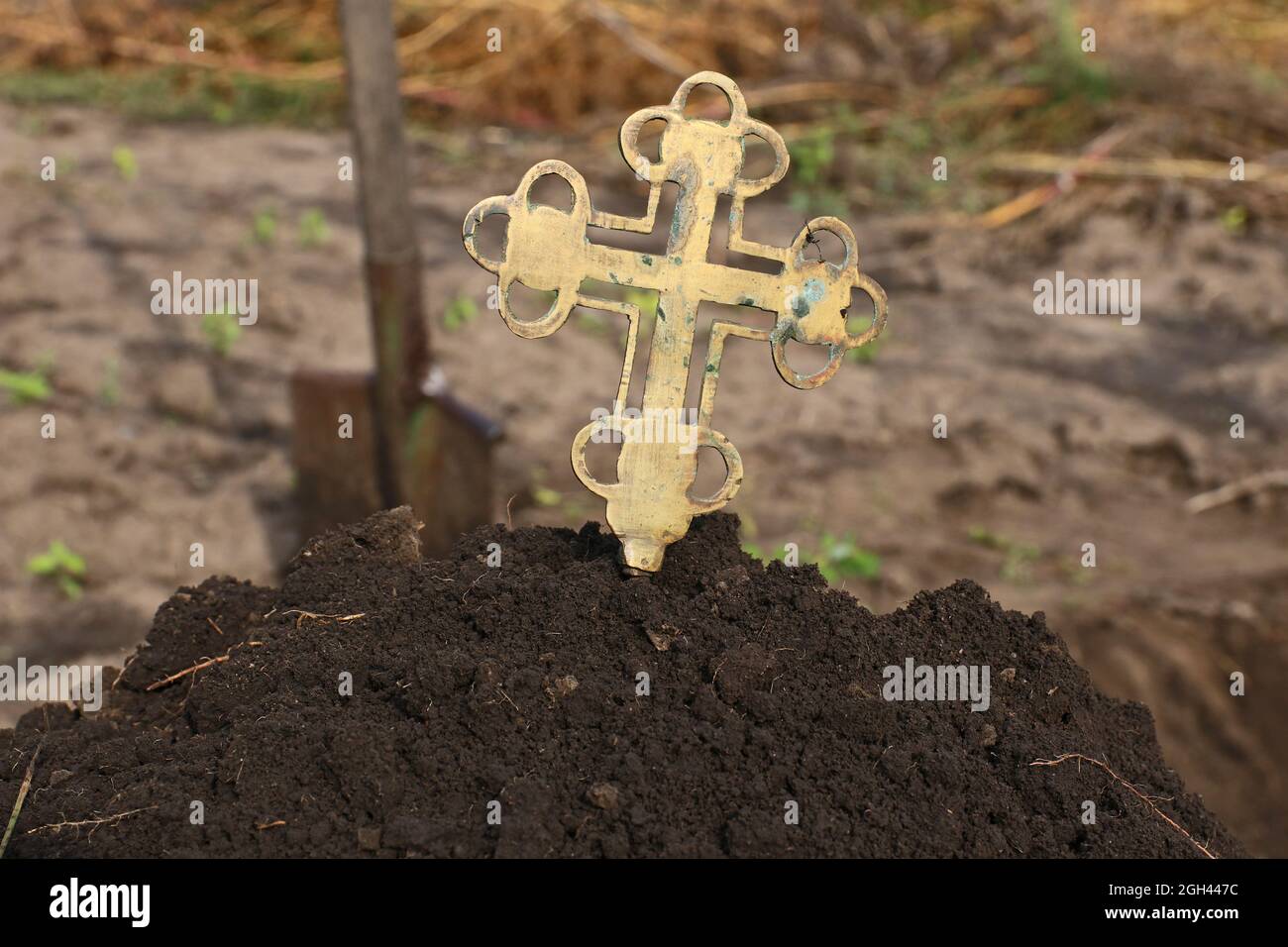 Une grave croix sort d'une pile de terre. Concept de mort. Banque D'Images