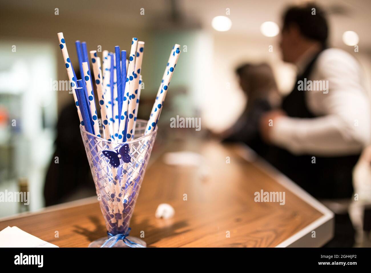 Un cliché sélectif de pailles à cocktail en plastique pointillées dans un pot en verre dans le bar Banque D'Images