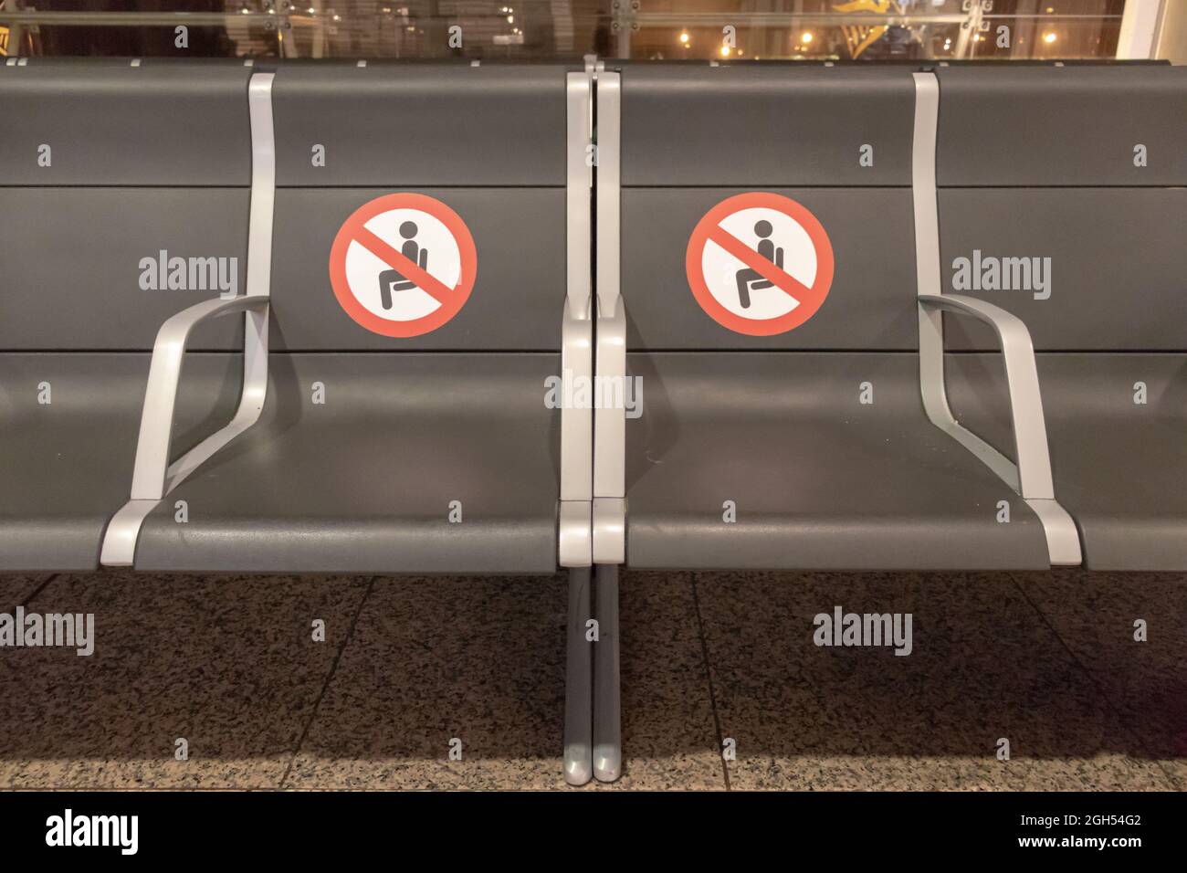 BARCELONE, ESPAGNE - AOÛT 18,2021 : rangée de sièges dans le terminal de départ de l'aéroport de Barcelone sans siège et avec les panneaux de distance Banque D'Images