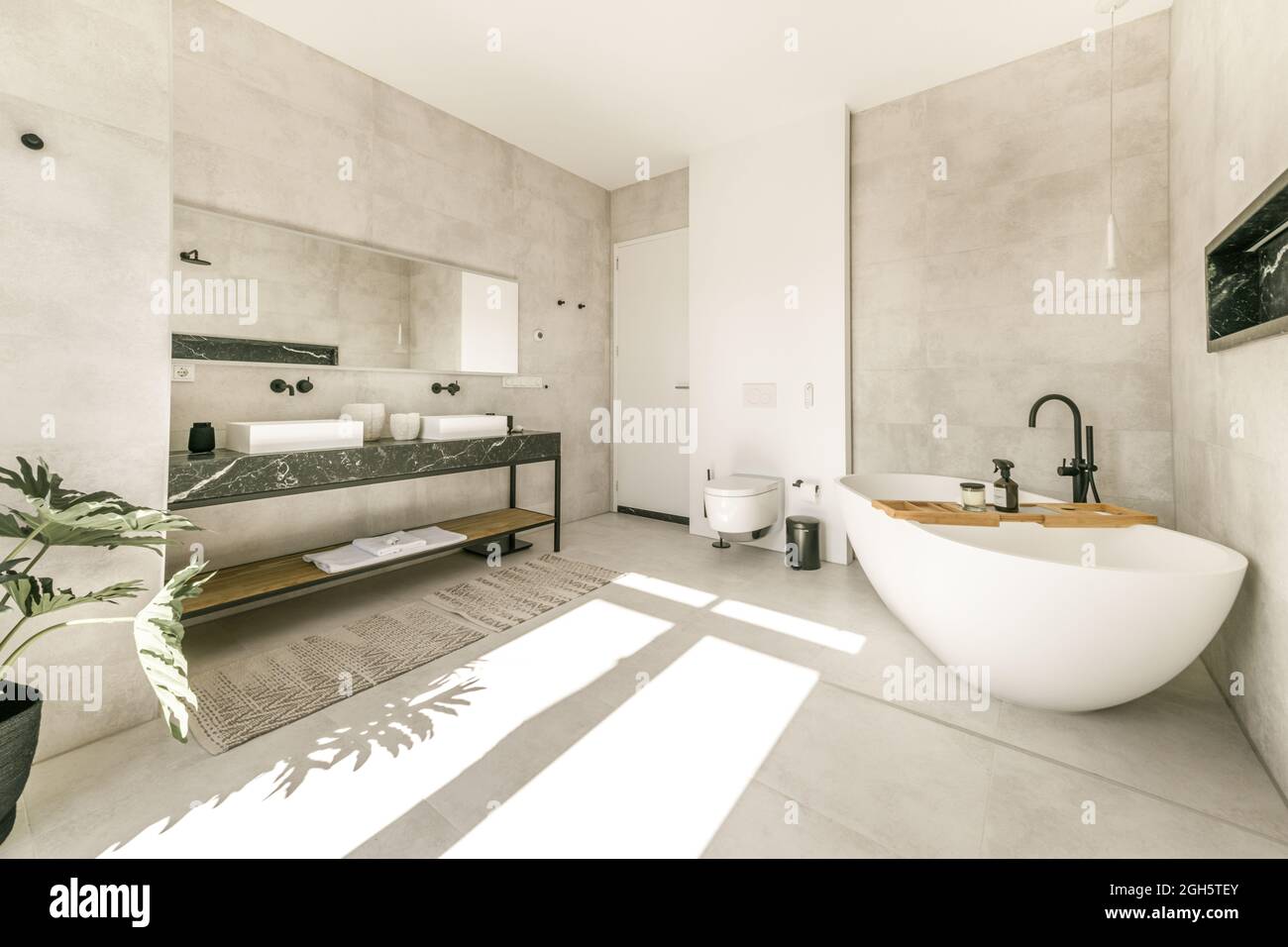 Intérieur moderne de la salle de bains avec baignoire blanche et toilettes  murales en céramique et double lavabo dans un style minimaliste Photo Stock  - Alamy