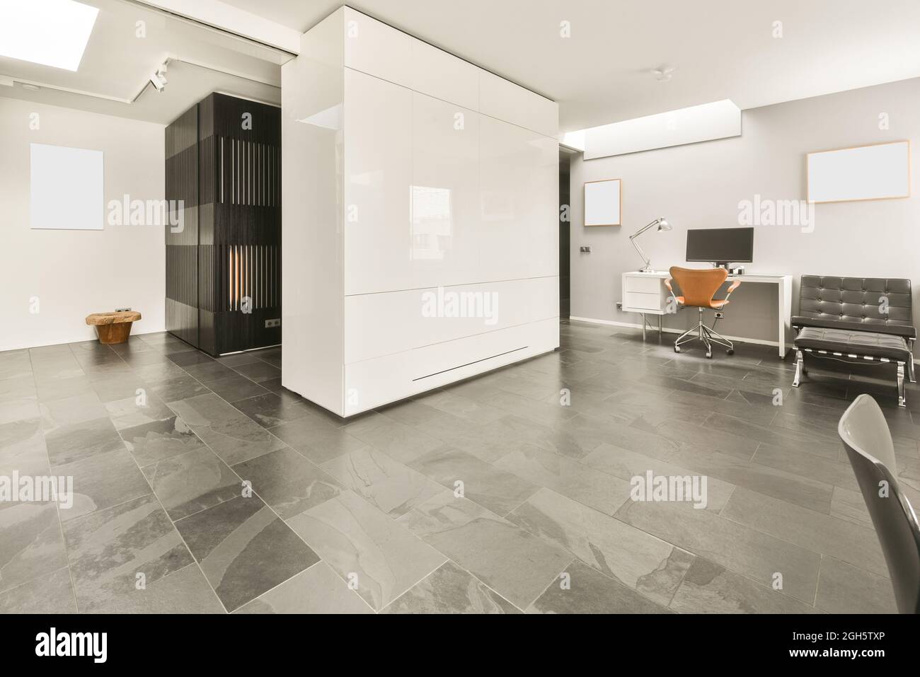 Décoration minimaliste de style loft dans un hall moderne spacieux avec murs blancs et sol en marbre, fauteuils et maquette blanche Banque D'Images