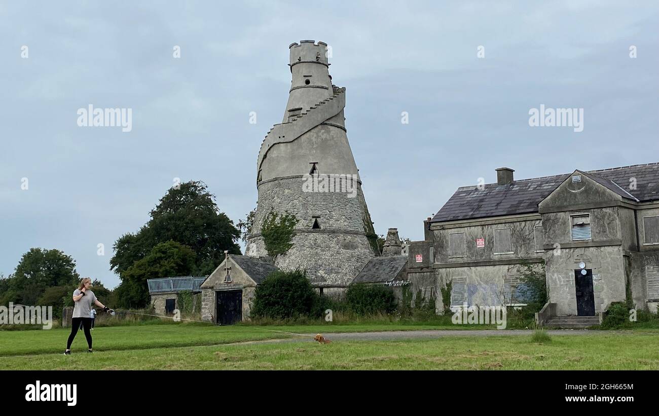 Une femme passe devant la magnifique Barn, une grange en forme de tire-bouchon construite en bordure de la maison Castletown Estate de la famille Conolly, qui borde Leixlip et Celbridge, en Irlande. Date de la photo: Dimanche 5 septembre 2021. Banque D'Images
