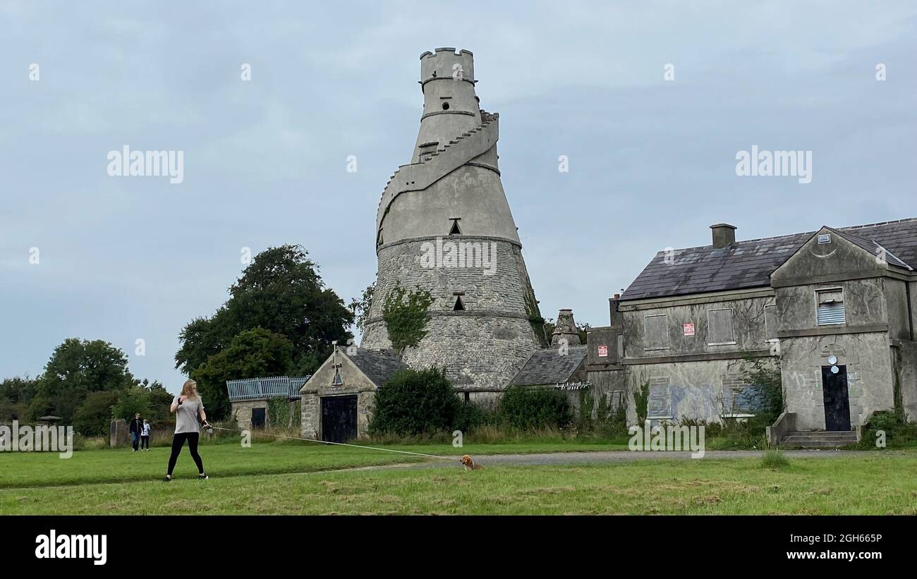 Une femme passe devant la magnifique Barn, une grange en forme de tire-bouchon construite en bordure de la maison Castletown Estate de la famille Conolly, qui borde Leixlip et Celbridge, en Irlande. Date de la photo: Dimanche 5 septembre 2021. Banque D'Images