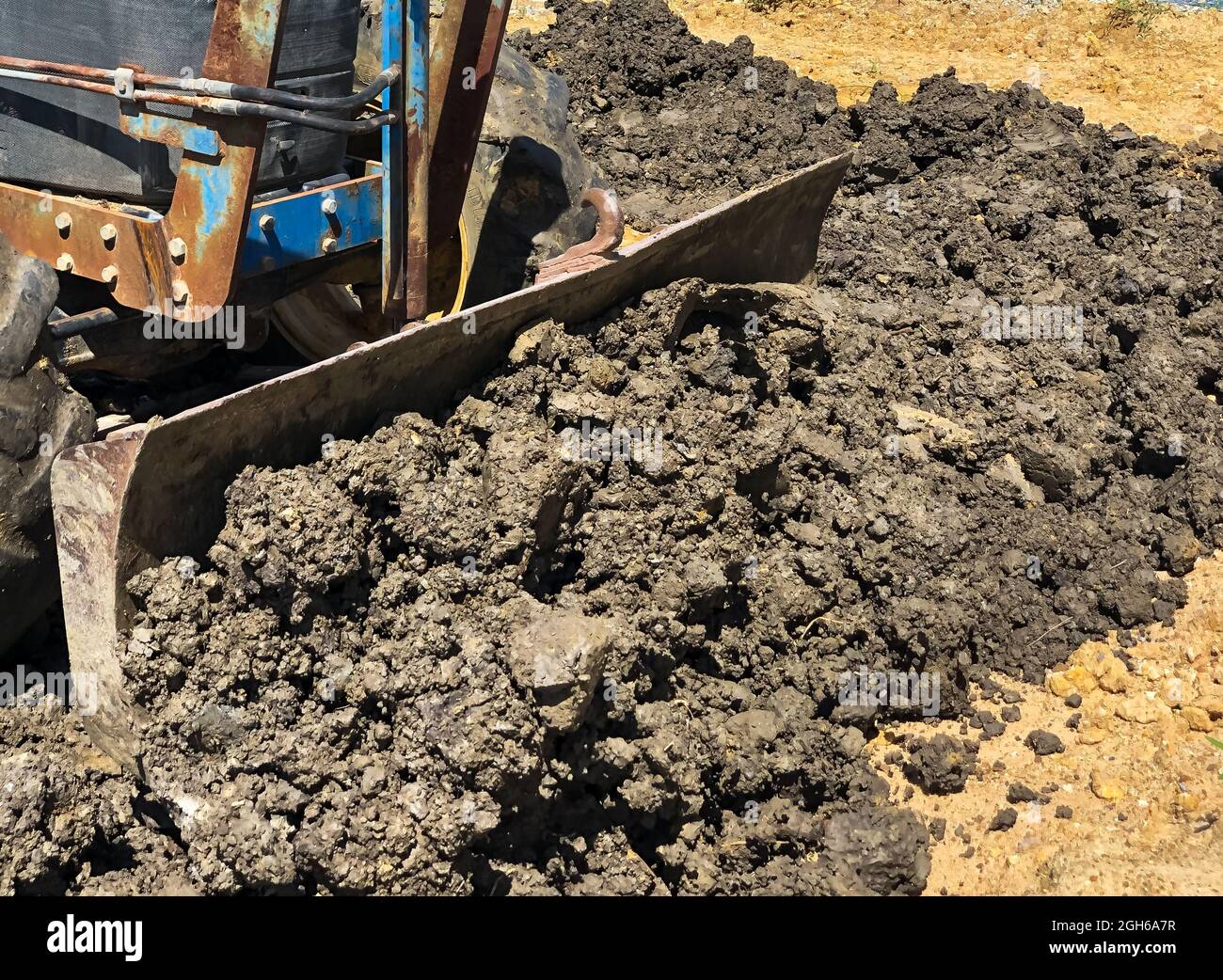 Le tracteur bleu règle le sol. Banque D'Images