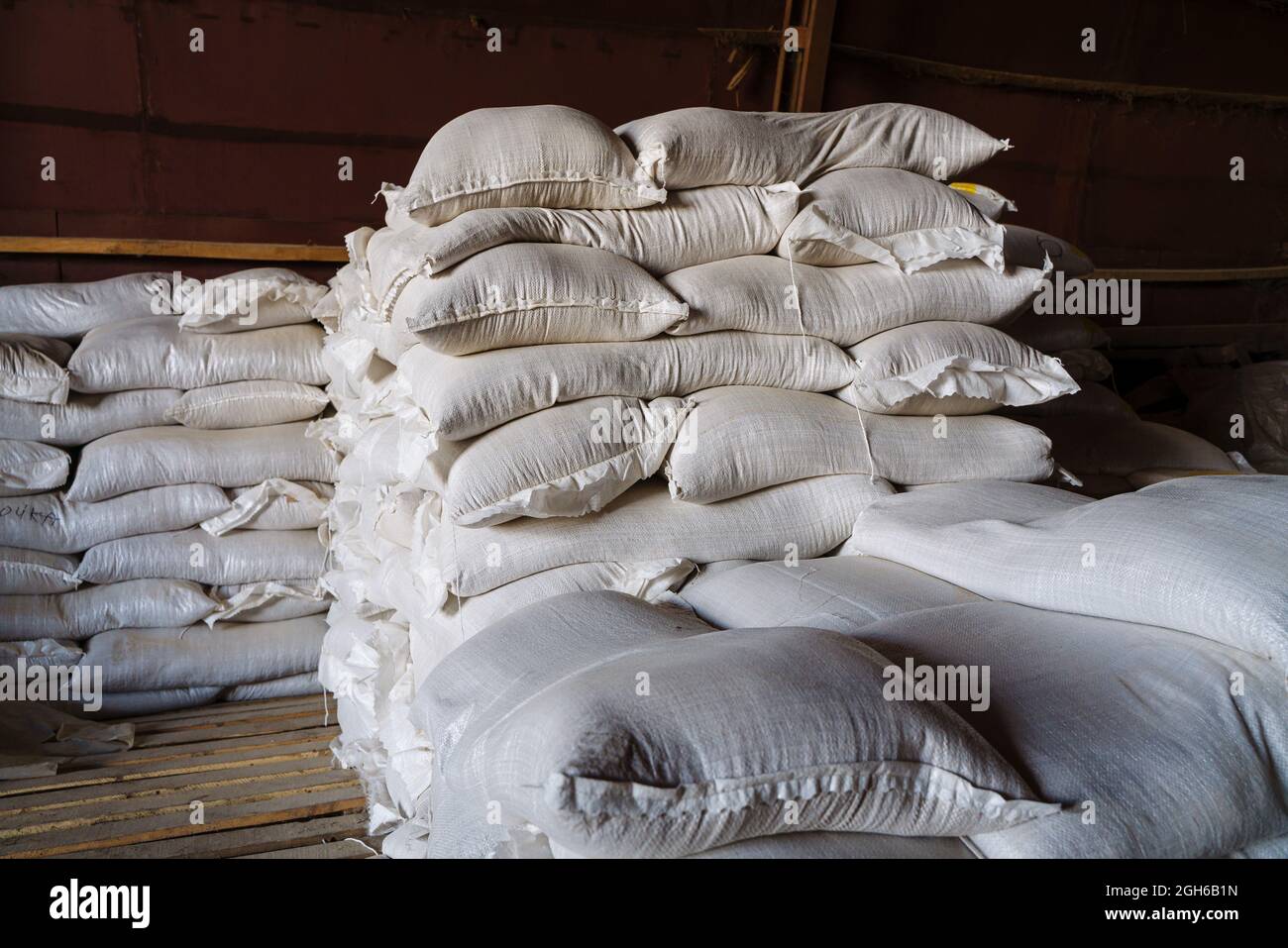 De grands sacs en tissu contenant des produits en vrac inconnus se trouvent dans l'entrepôt. Une image illustrant les produits confisqués en raison de sanctions, ou le Banque D'Images