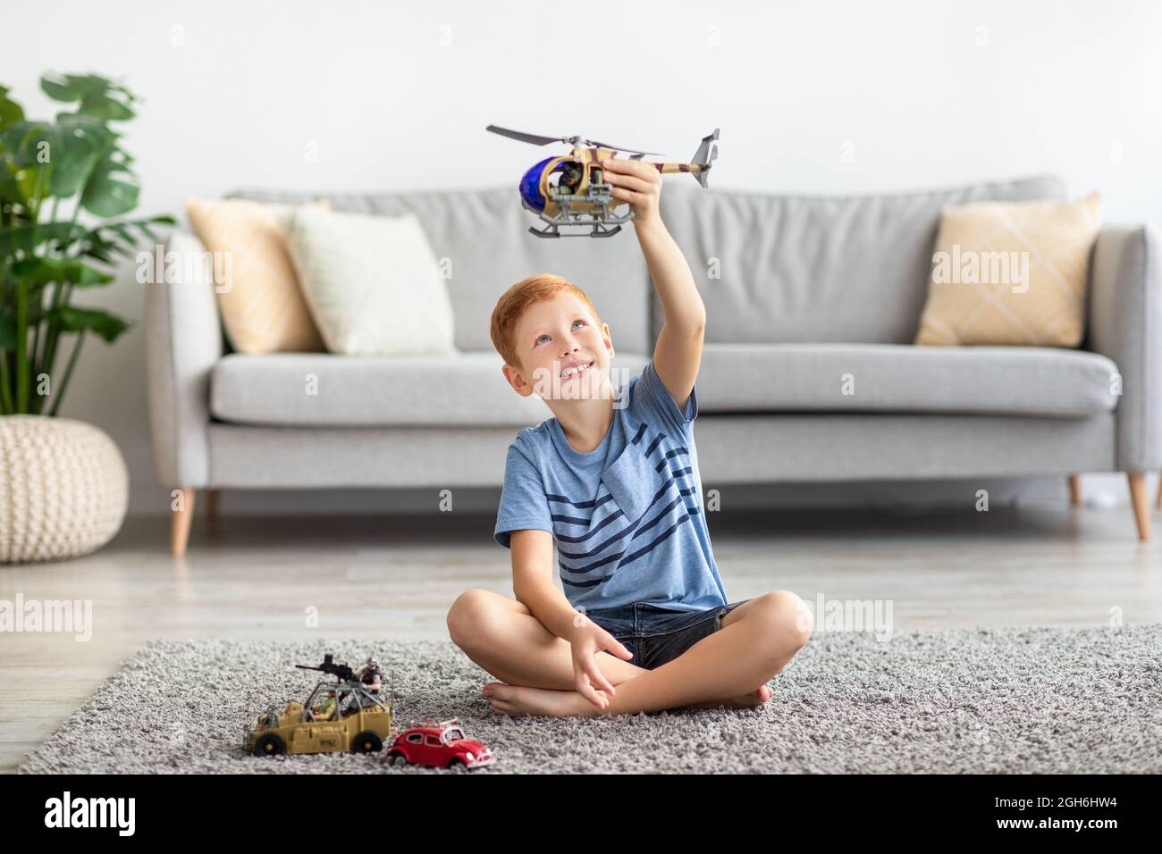 Enfant jouant seul avec des jouets à la maison Banque D'Images