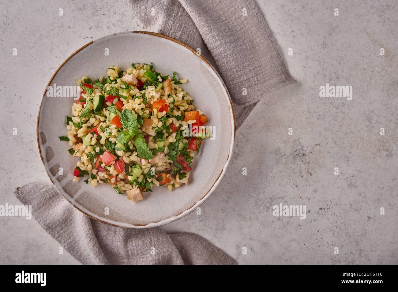 Salade de tabac. Plat traditionnel moyen-oriental ou arabe avec persil, menthe, bulgur, tomates dans un bol sur serviette. Vue de dessus. Copier l'espace Banque D'Images