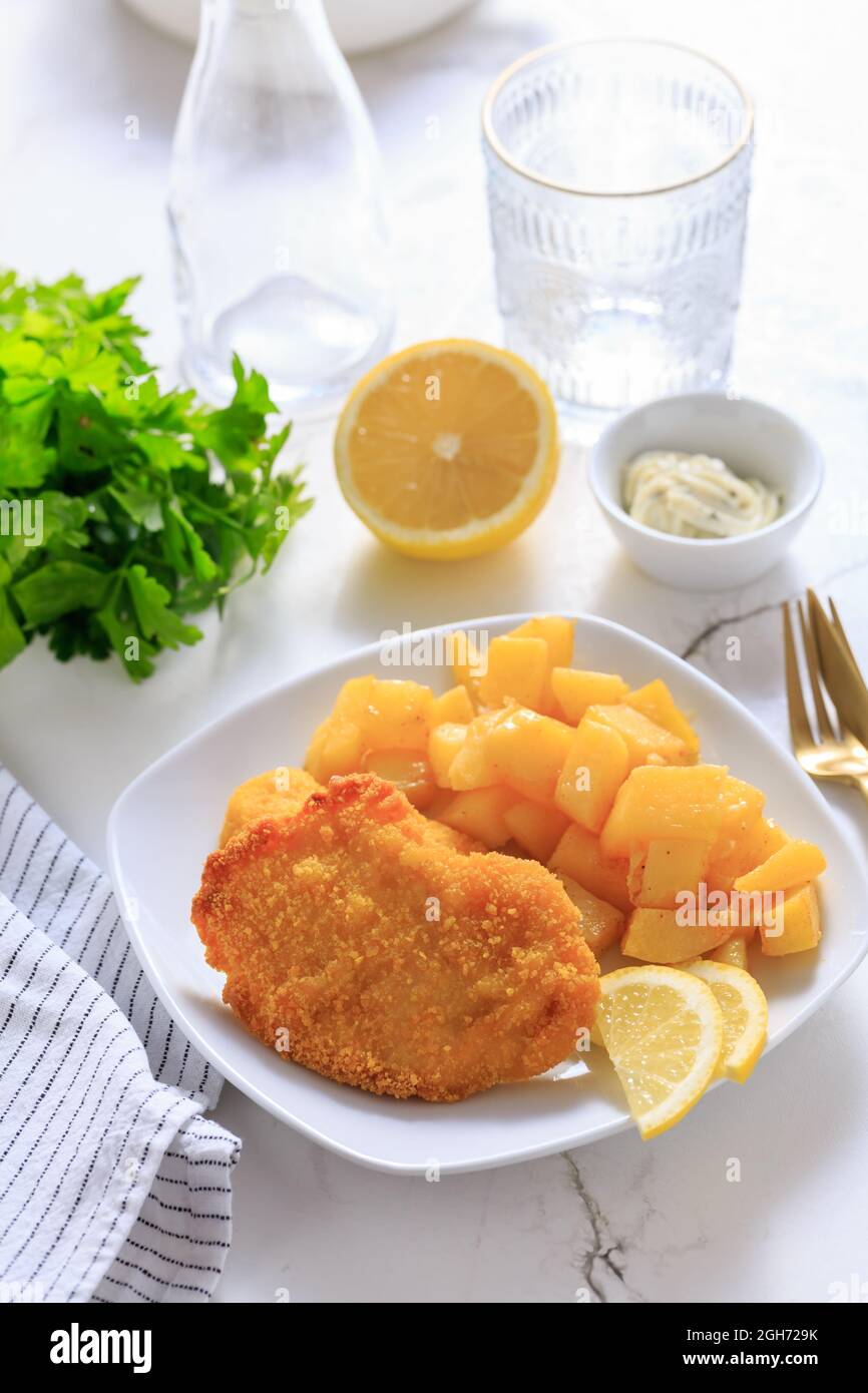 Escalope de poulet maison avec pommes de terre au four, mayonnaise et citron Banque D'Images