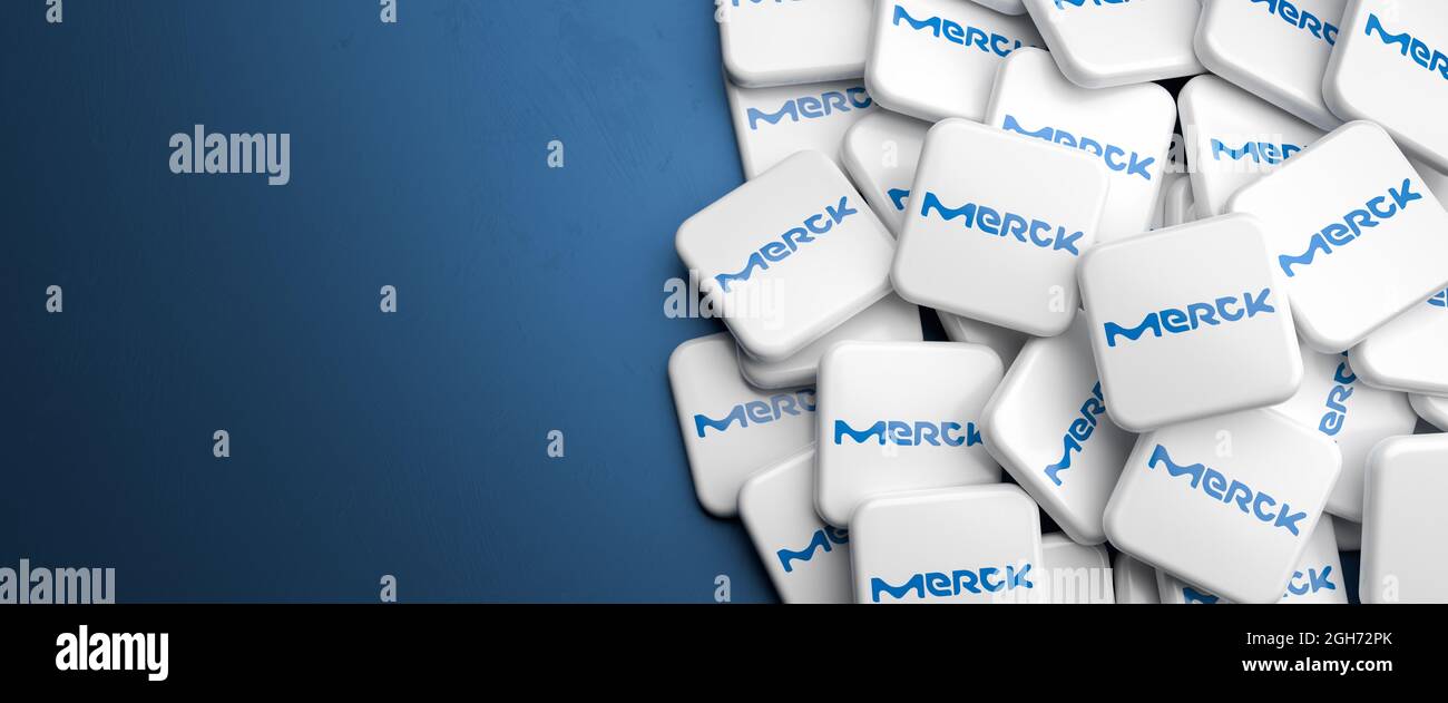 Logos de la société allemande de science et de technologie Merck KGaA sur un tas sur une table. Copier l'espace. Format de bannière Web. Banque D'Images
