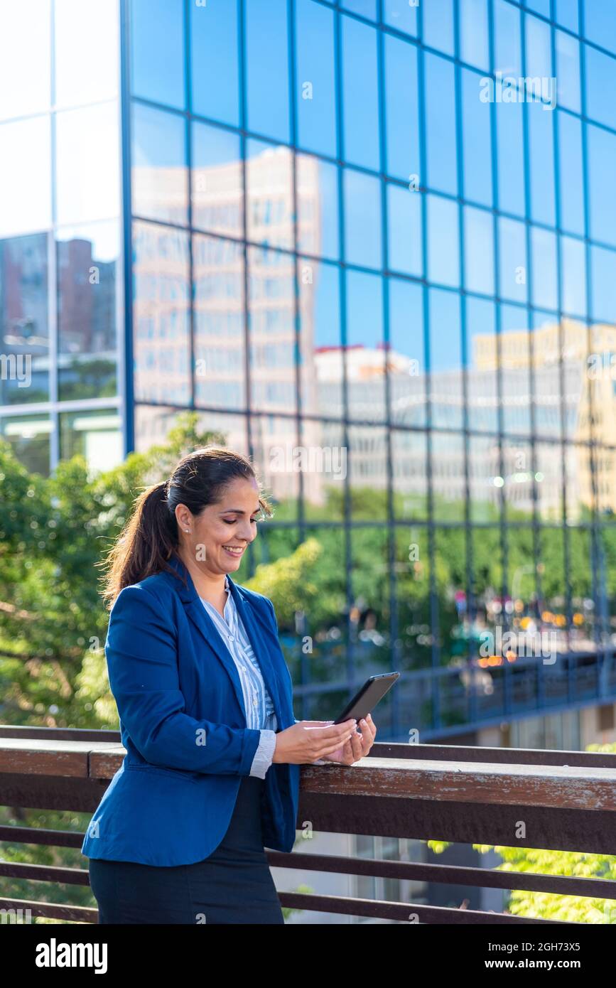 Femme d'affaires de taille moyenne d'adulte de race blanche avec téléphone mobile dans la ville Banque D'Images