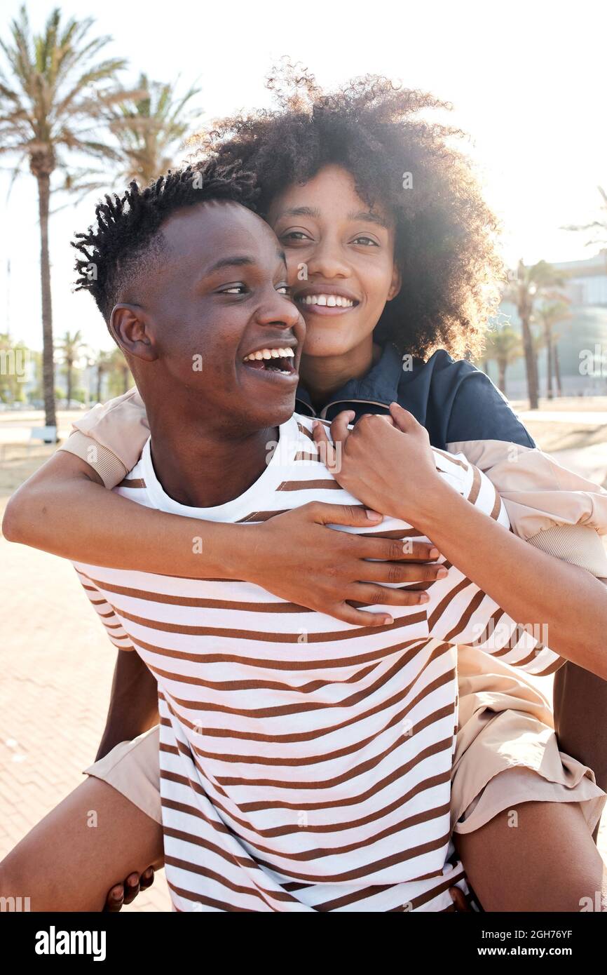 Portrait vertical d'un jeune couple afro-américain amoureux. La petite amie qui soutient le petit ami. Banque D'Images