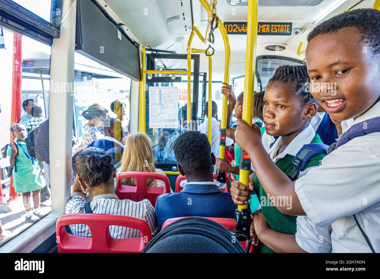 Cape Town Afrique du Sud, MyCiTi public bus équitation à la maison, Black boy élèves portant l'uniforme scolaire fille enfants cavaliers Banque D'Images