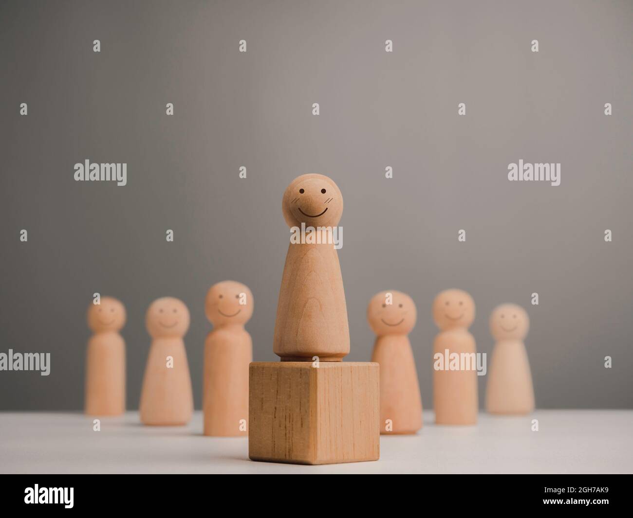 Leader femme, influenceur, femmes dans le concept de poste de direction. Figurine en bois, femme heureuse et forte avec sourire debout sur la boîte et l'équipe, mini Banque D'Images