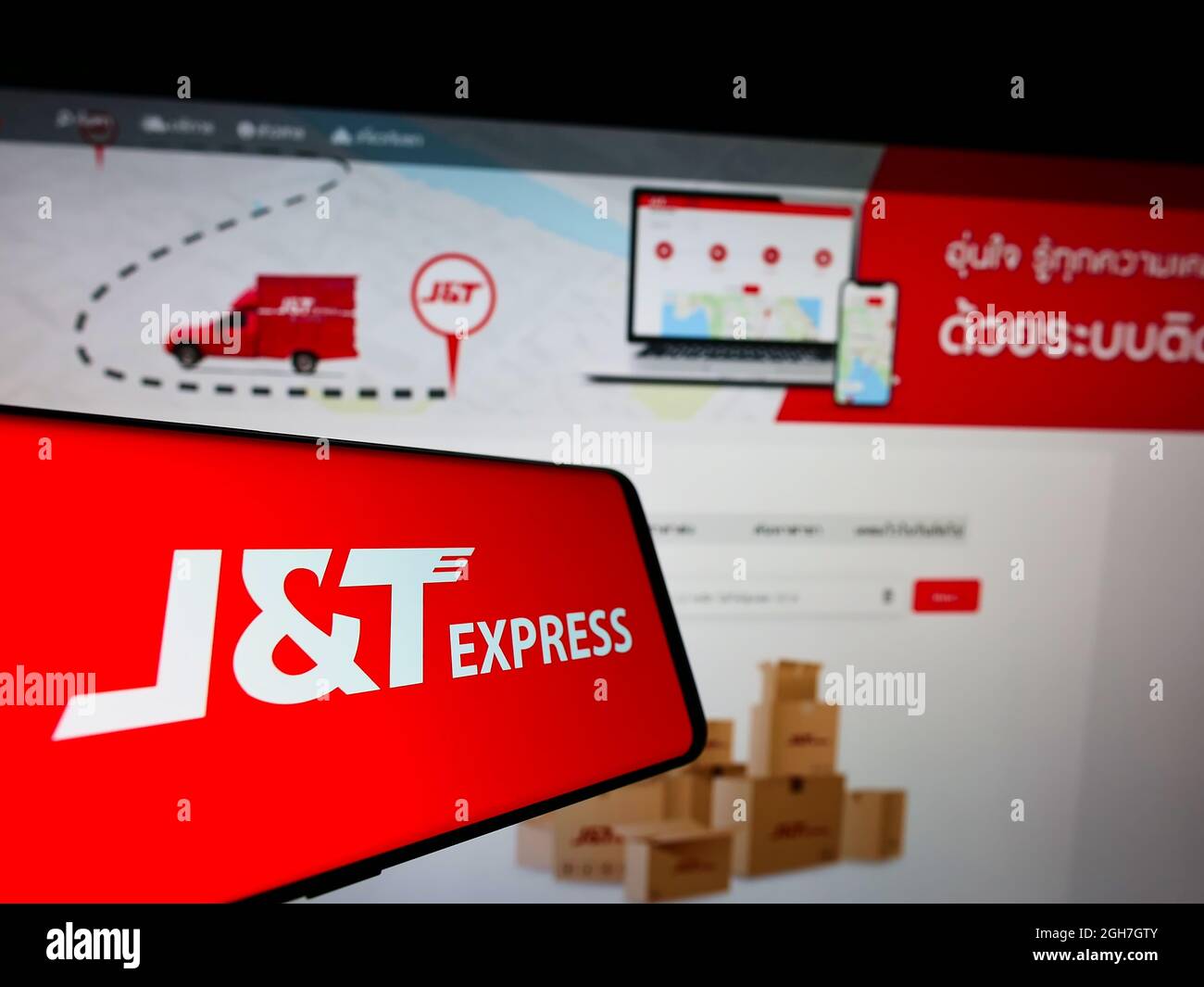 Téléphone portable avec logo de la société indonésienne PT Global Jet Express (JT) à l'écran devant le site Web des entreprises. Effectuez la mise au point au centre-droit de l'écran du téléphone. Banque D'Images