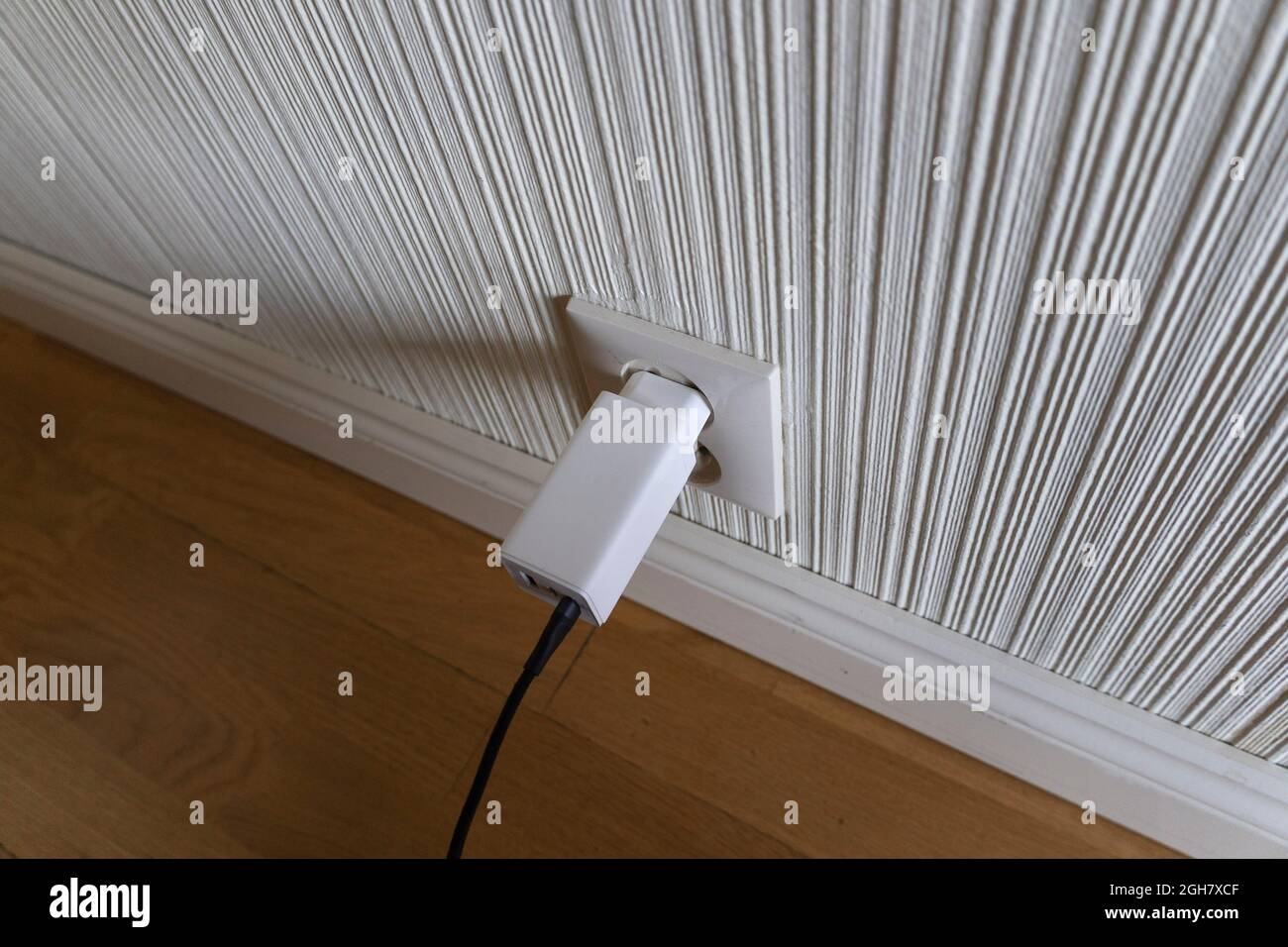 Chargeur de téléphone USB blanc branché sur une prise secteur Banque D'Images