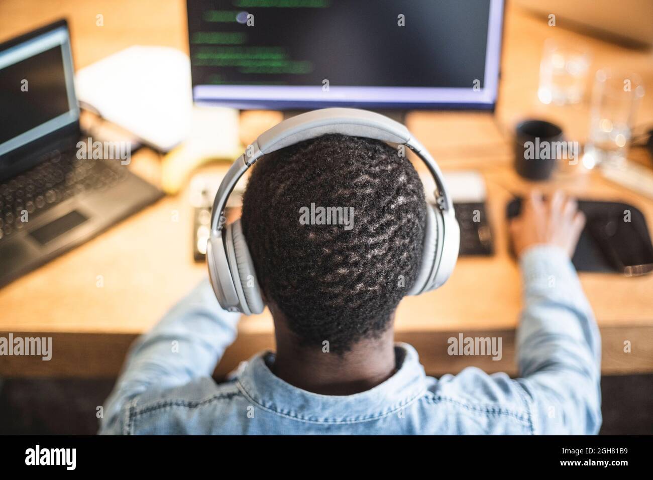 Vue arrière du pirate travaillant sur un ordinateur au bureau Banque D'Images