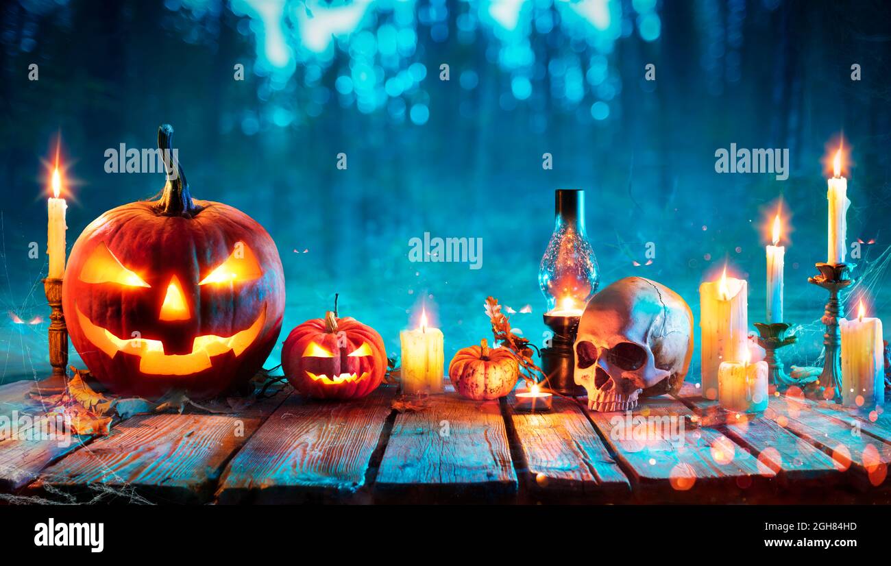 Halloween la nuit - Lanterne Jack O sur table avec bougies dans la forêt Banque D'Images