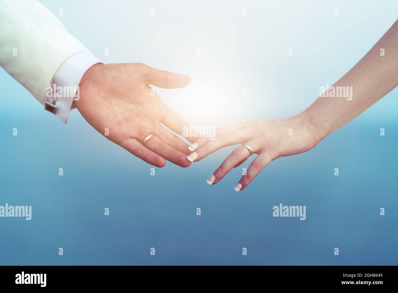 Les mains de la mariée et du marié se touchent et les doigts se touchent avec l'anneau de mariage comme symbole de liaison. Photo de haute qualité Banque D'Images