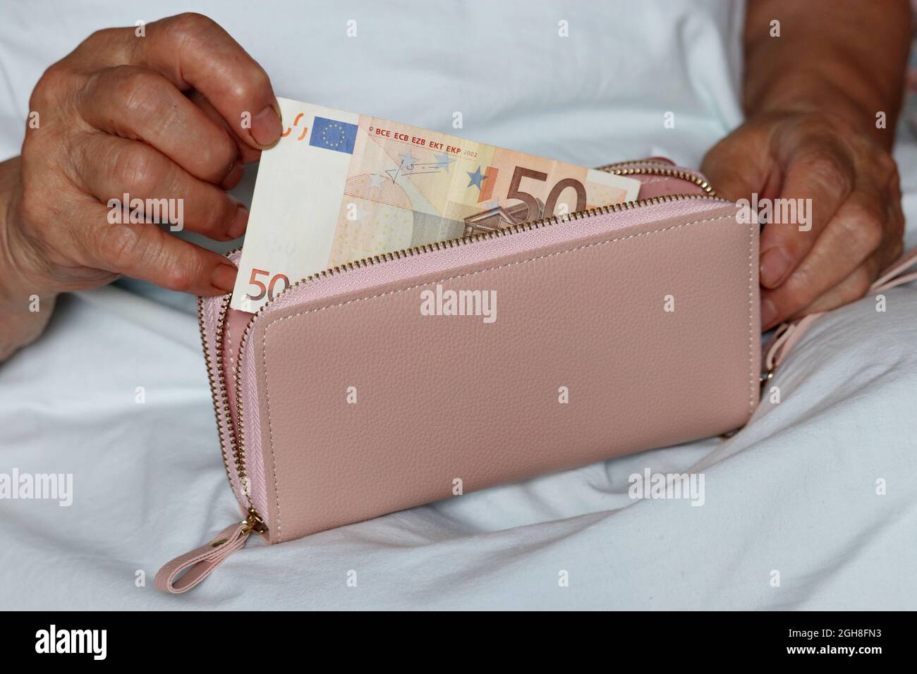 Une femme âgée prend une note d'euro de son portefeuille assis dans son  lit. Concept de paiements de pension, médicaments payés, pensionné avec de  l'argent Photo Stock - Alamy