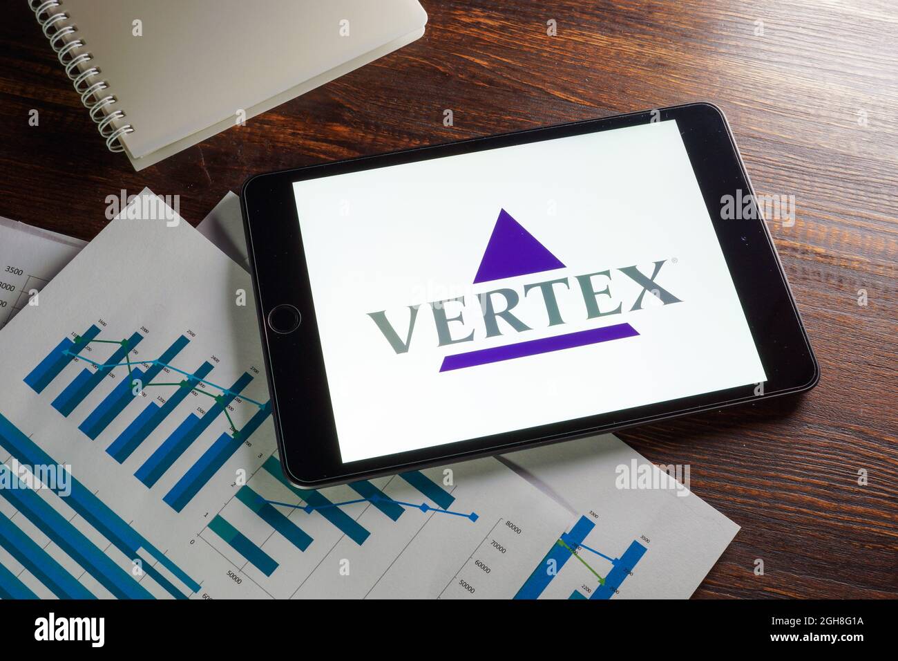 KIEV, UKRAINE - 21 août 2021. Papiers avec cartes et logo de la société Vertex Pharmaceuticals. Banque D'Images