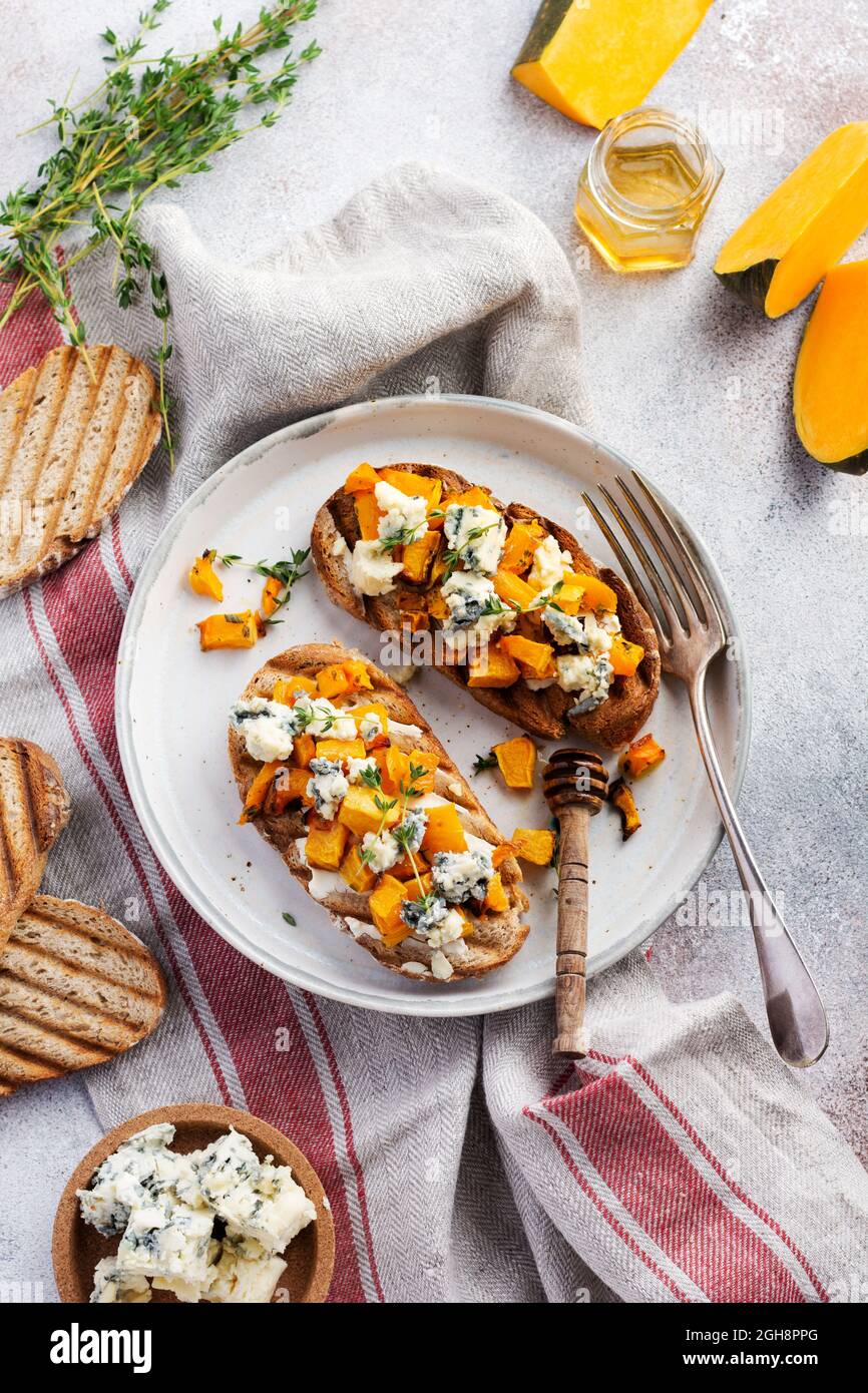 Sandwich au potiron cuit au fromage dorblu avec moule bleu, miel et thym sur un fond de béton ancien et léger. Vue de dessus Banque D'Images