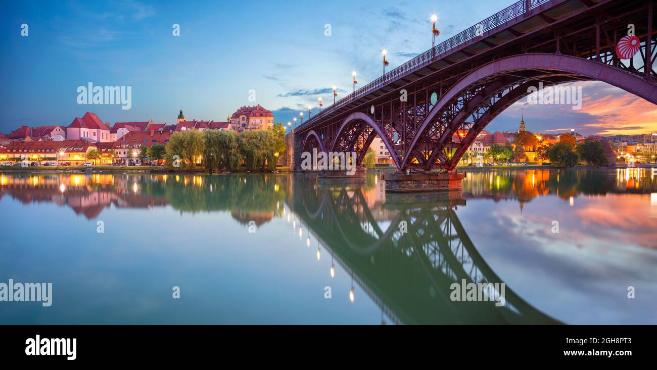 Maribor, Slovénie. Paysage urbain de Maribor, Slovénie au beau lever du soleil d'été avec le reflet de la ville dans le fleuve Drava. Banque D'Images