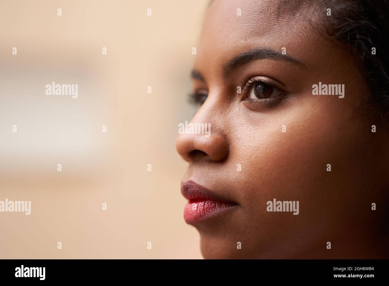 Gros plan des yeux attrayants d'une femme afro-américaine, regardant à l'extérieur par la fenêtre. Banque D'Images