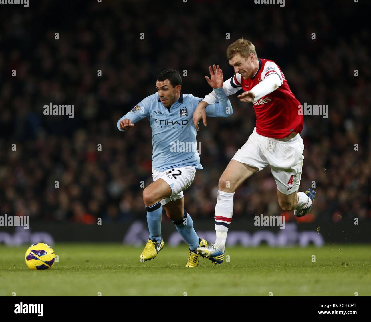 Arsenal's Per Mertesacker se dispute avec Carlos Tevez de Manchester City lors de la Barclays Premier League entre Arsenal et Manchester City au stade Emirates de Londres le 13 janvier 2013. David Klein Banque D'Images