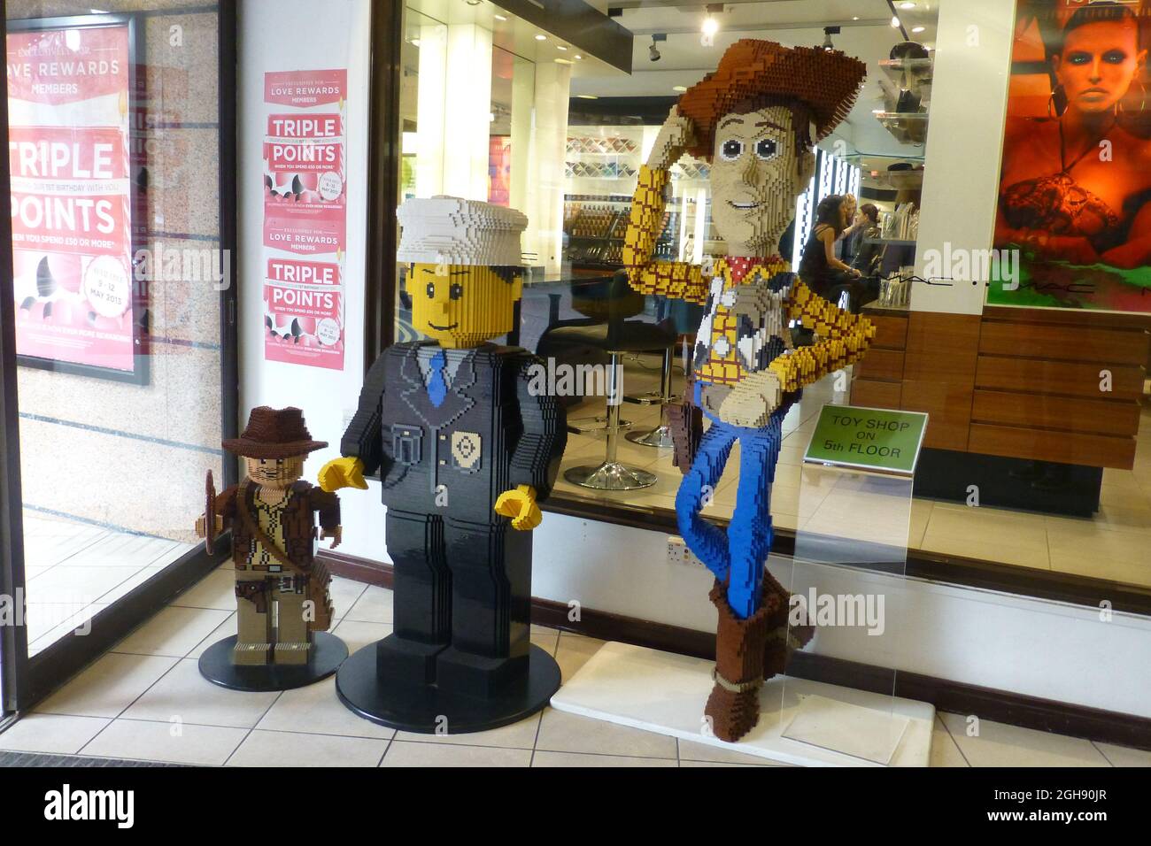 Woody dans la fenêtre du magasin Lego man cow-boy boutique avant chapeau  bottes jeans plancher debout chemise à carreaux sourire souriant poser amis  poser porte Photo Stock - Alamy