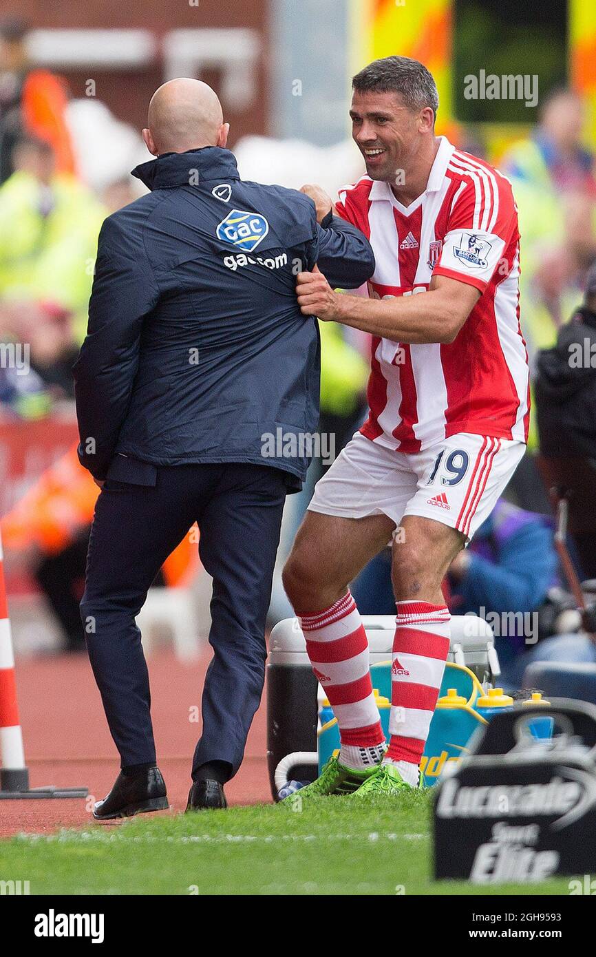 Jon Walters de Stoke est entré en collision avec Ian Holloway, directeur de Crystal Palace, lors du match de la Barclays Premier League entre Stoke City et Crystal Palace au Britannia Stadium de Manchester, au Royaume-Uni, le 24 août 2013. Banque D'Images