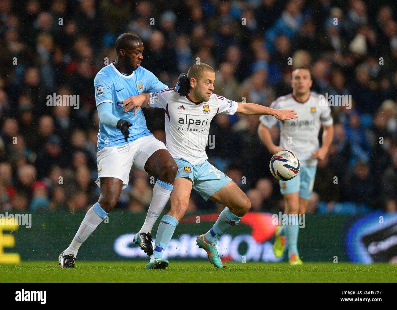 Yaya Toure de Manchester City s'attaque à Joe Cole de West Ham United lors du match de la demi-finale de la première jambe de la Capital One Cup entre Manchester City et West Ham Utd qui s'est tenu au stade Etihad à Manchester, en Angleterre, le 8 janvier 2014. Banque D'Images