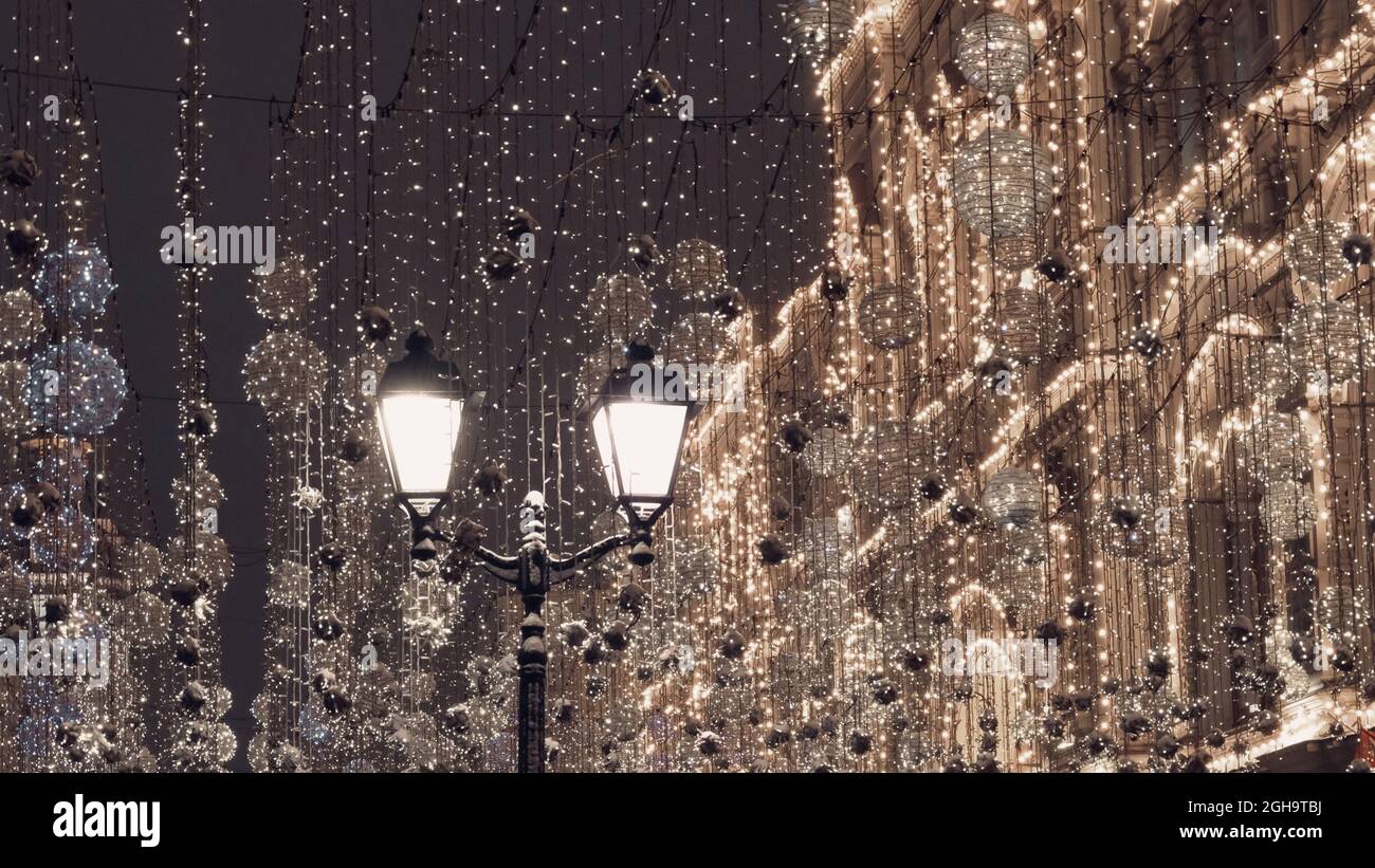 Illuminations de Noël festives dans les rues urbaines de Moscou. Lanternes et guirlandes illuminant la nuit, créant noël nouvel an humeur en attente de vacances. Banque D'Images