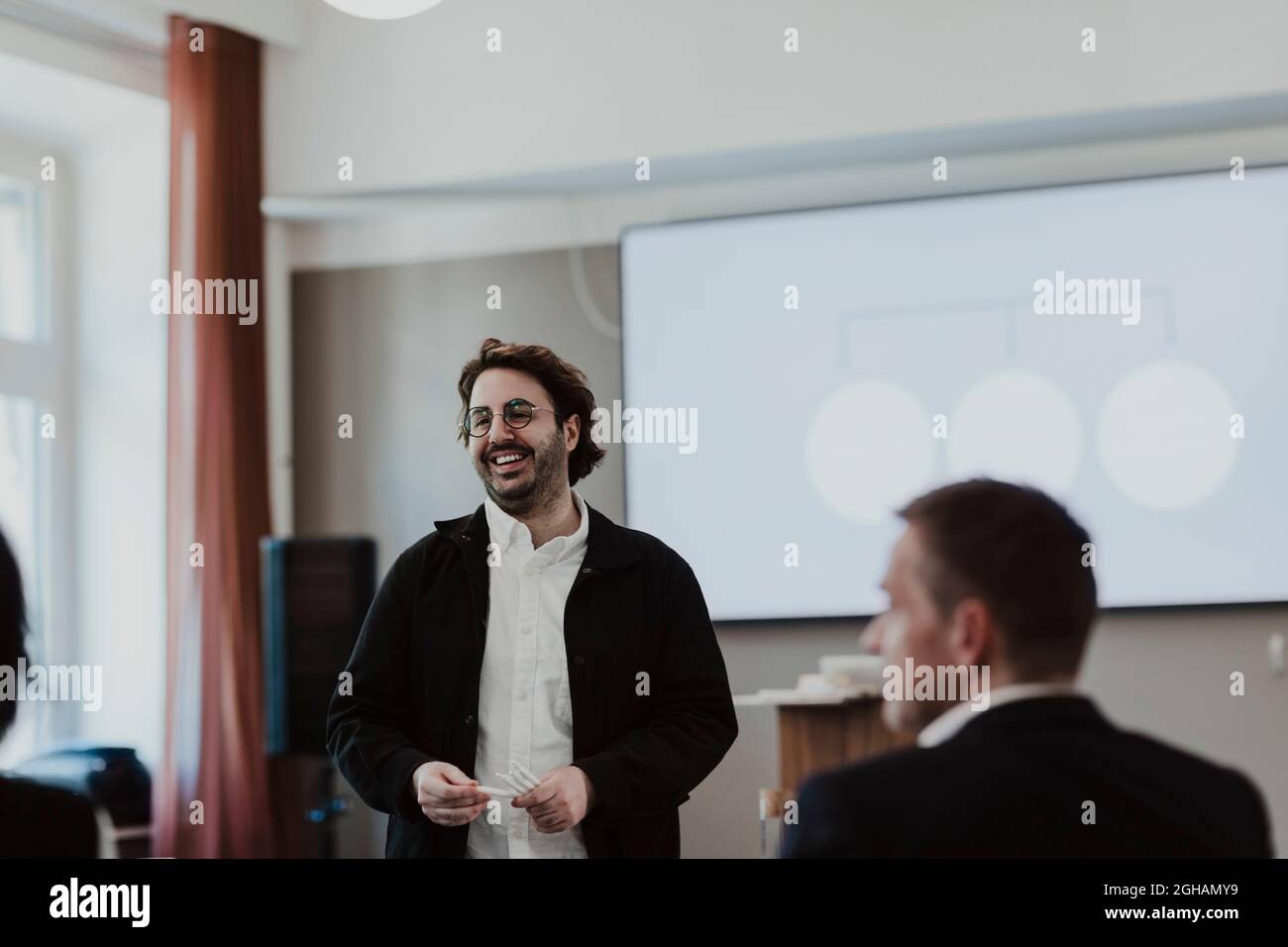 Homme d'affaires souriant discutant avec un employé en classe d'éducation Banque D'Images