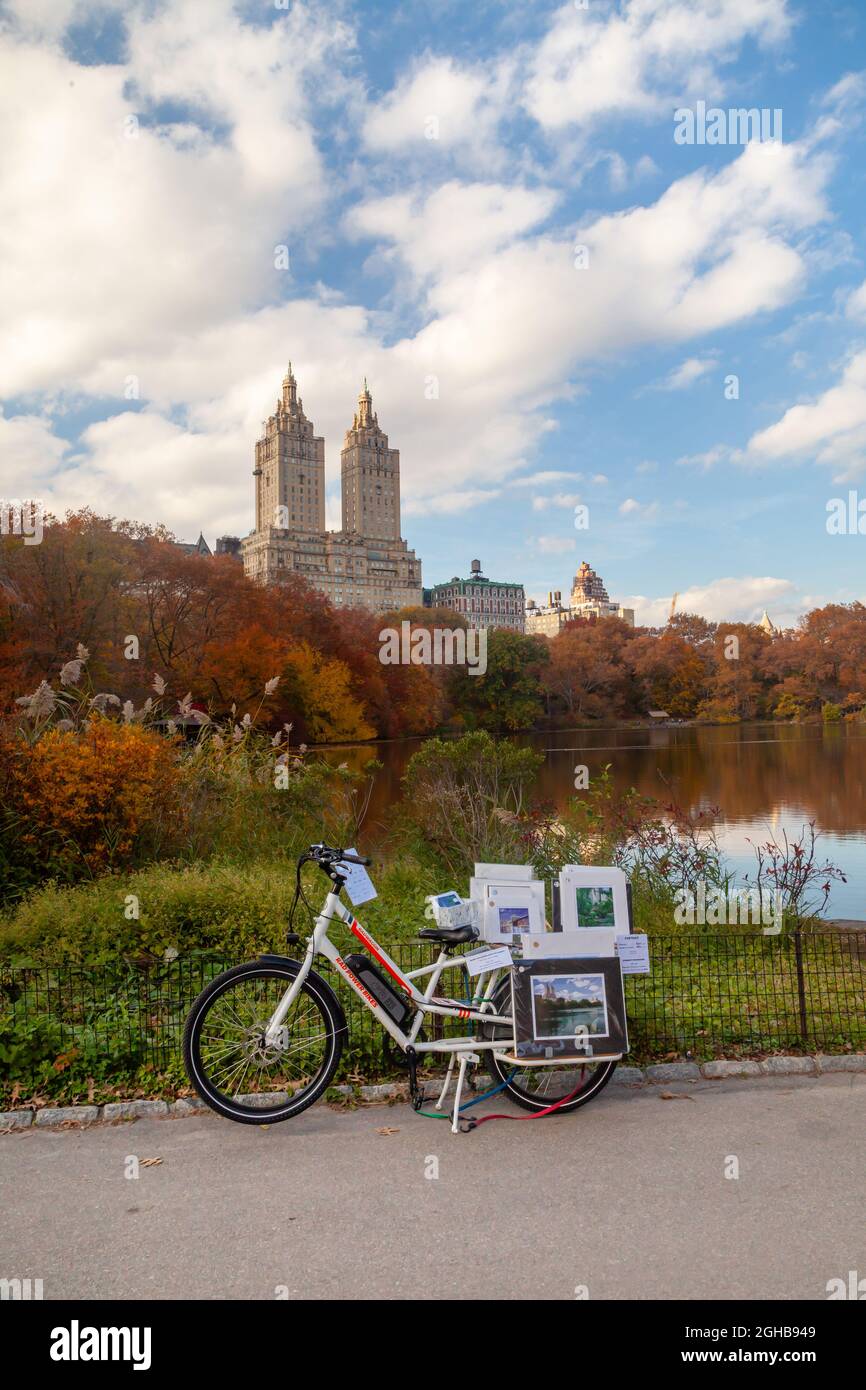 Central Park en automne avec vue sur Upper West Manhattan Skycabper El Dorado. Tombez dans Central Park et un vendeur de rue de photo au bord du lac. Banque D'Images