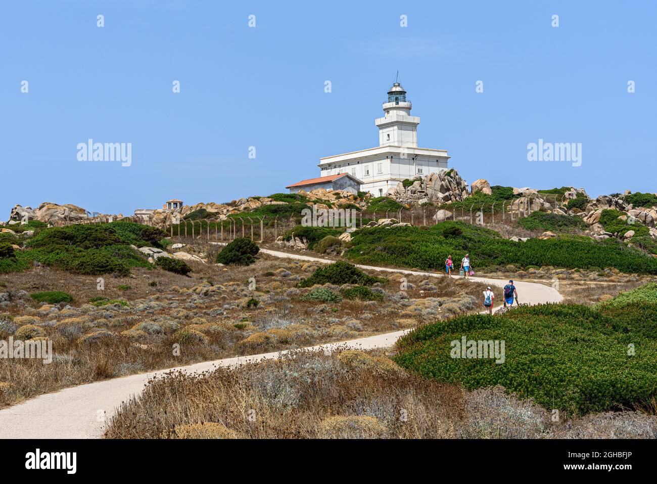 Personnes marchant sur le chemin menant au phare de Capo Testa en Sardaigne Banque D'Images