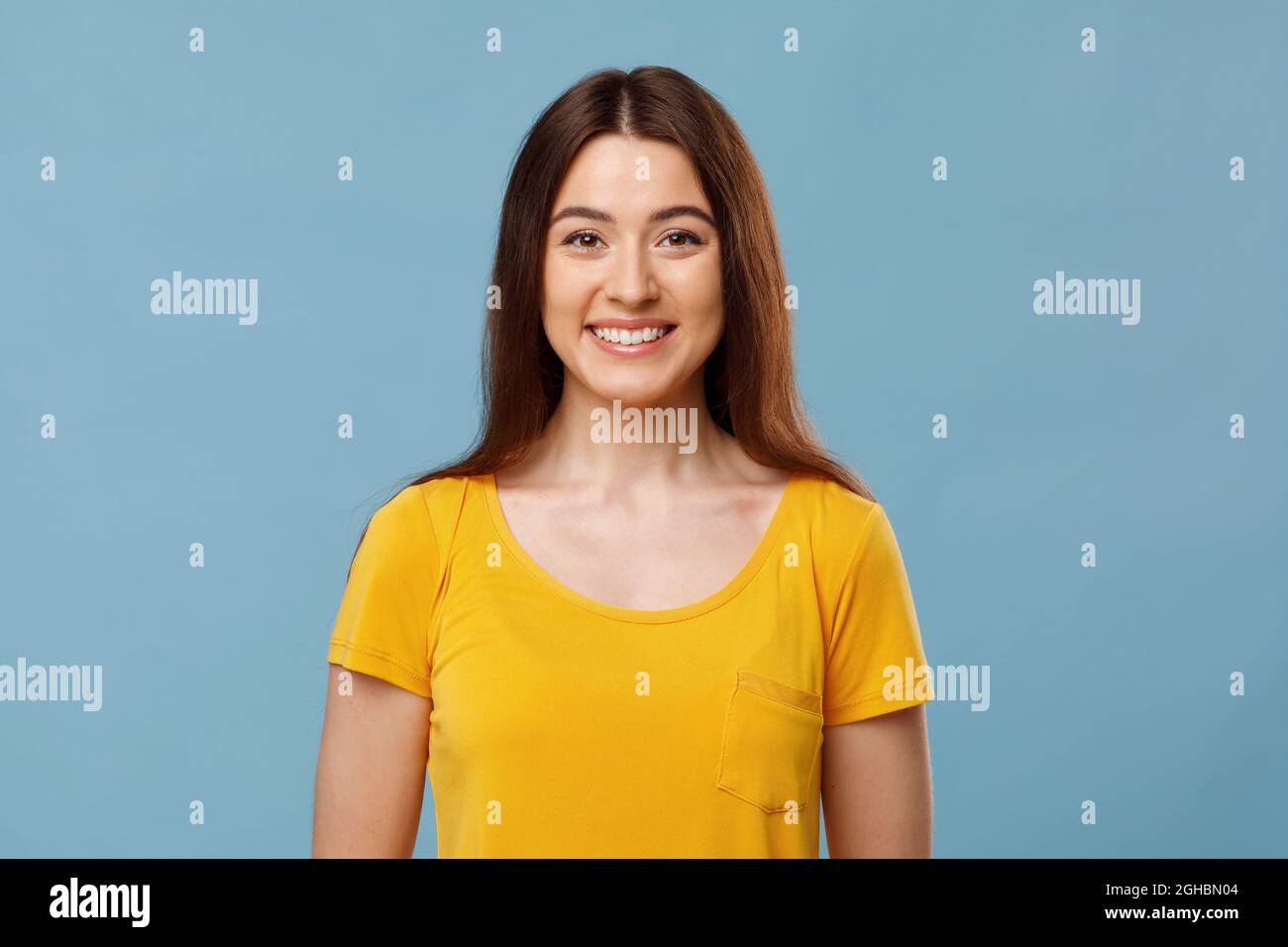Joyeuse jolie jeune femme souriant sur fond bleu Banque D'Images