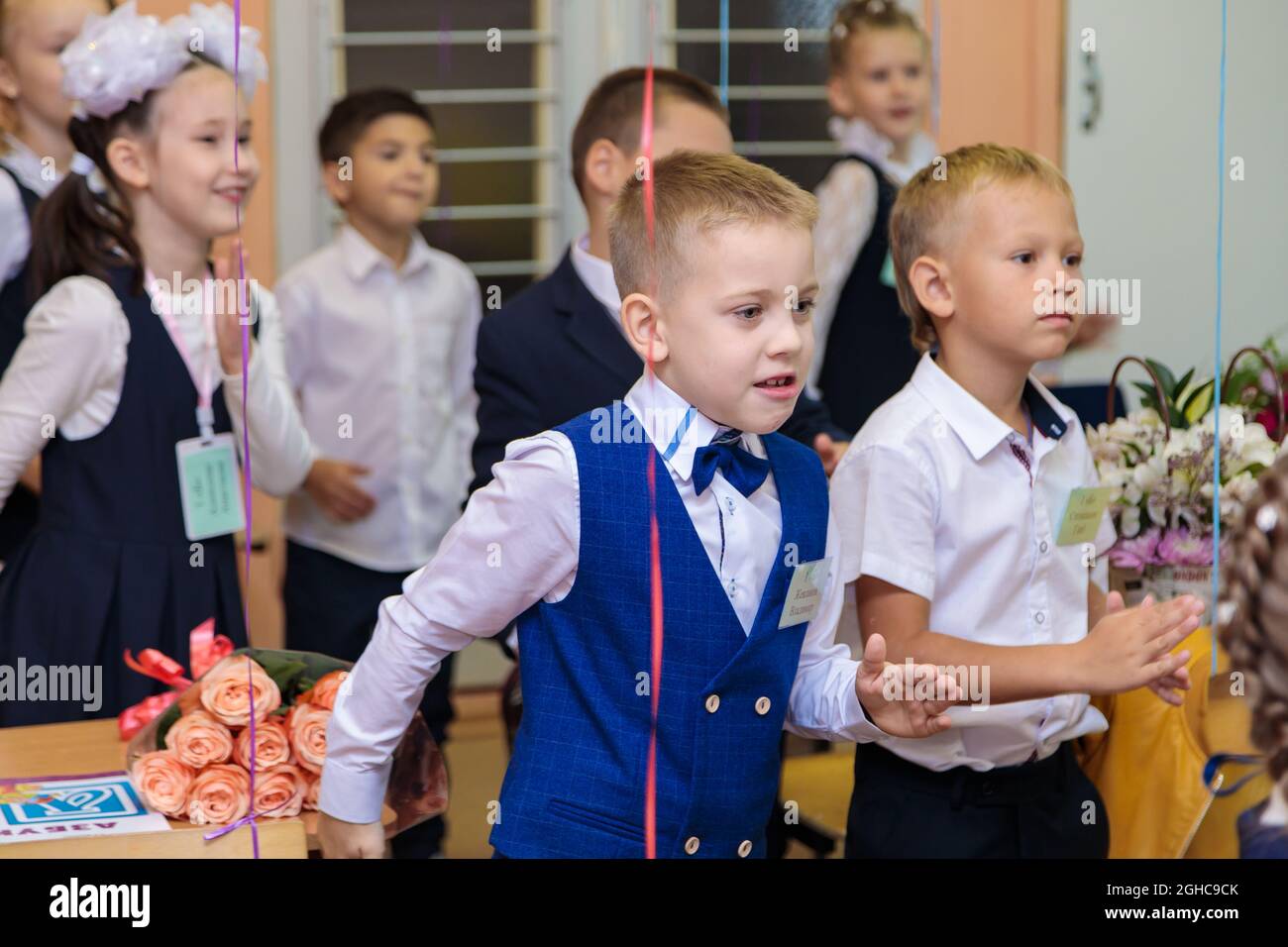 Les élèves de première classe effectuent un échauffement en se tenant debout. Elle est à l'école de première année. Moscou, Russie, 1er septembre 2021 Banque D'Images