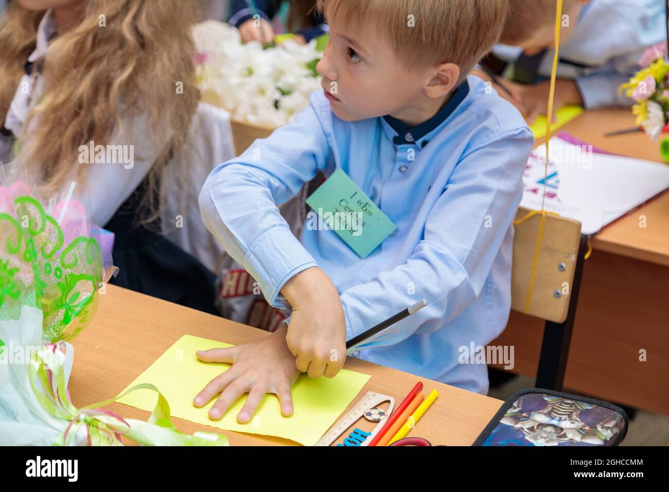 La première niveleuse mène un crayon sur une feuille de papier. École, journée du savoir. Moscou, Russie, 1er septembre 2021 Banque D'Images