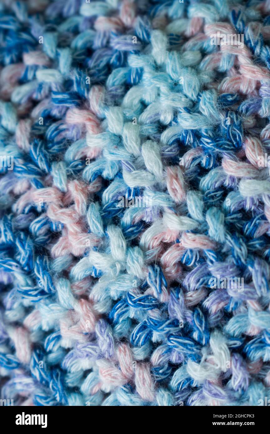 Gros plan sur la texture de laine tricotée bleue et rose d'un pull Banque D'Images