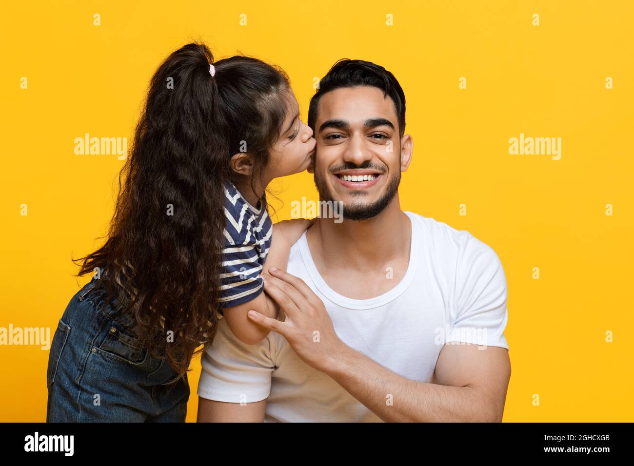 J'adore mon papa. Petite fille mignonne embrassant son papa arabe heureux Banque D'Images