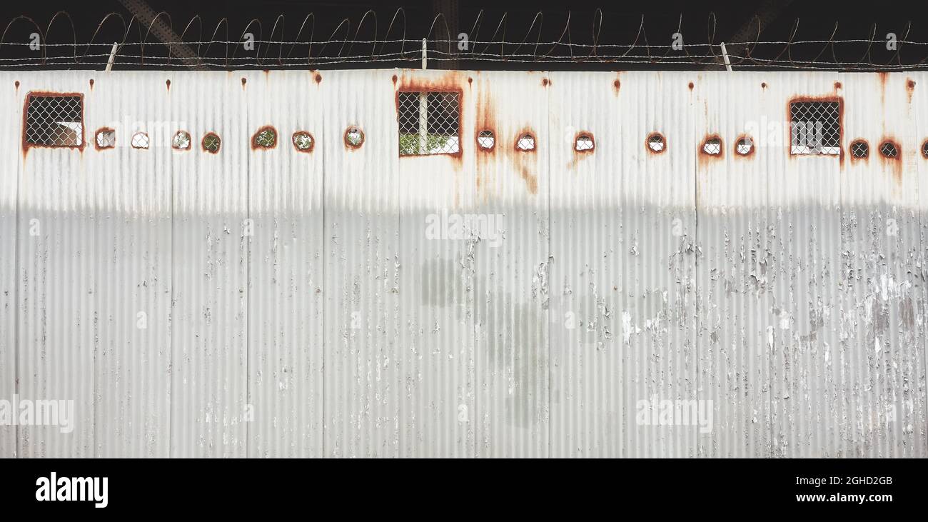 Paroi en acier ondulé avec fil barré, application de teintes de couleur. Banque D'Images