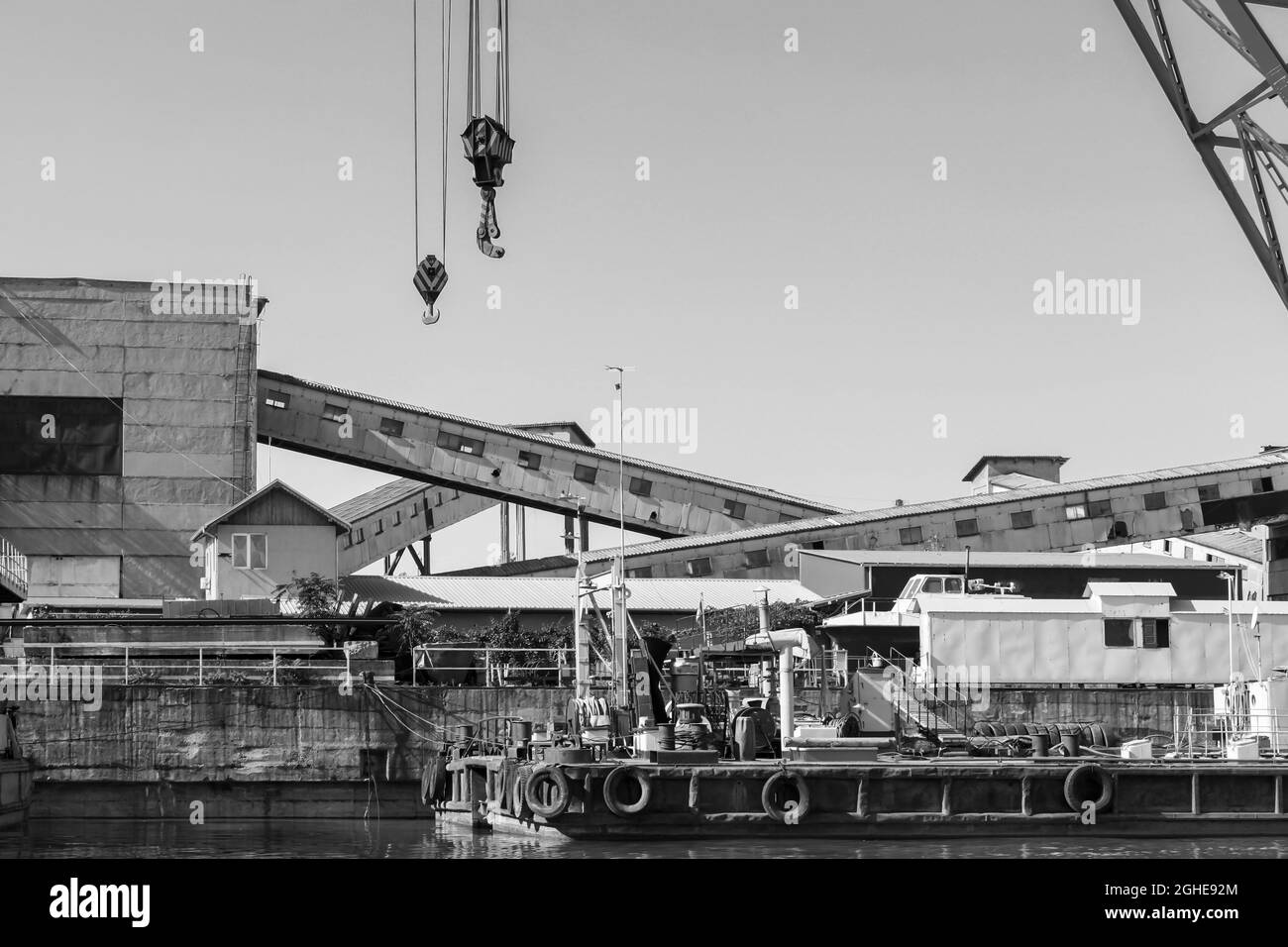 Port industriel, photo noir et blanc avec grues et matériel de chargement. Port de la ruse, côte du Danube, Bulgarie Banque D'Images