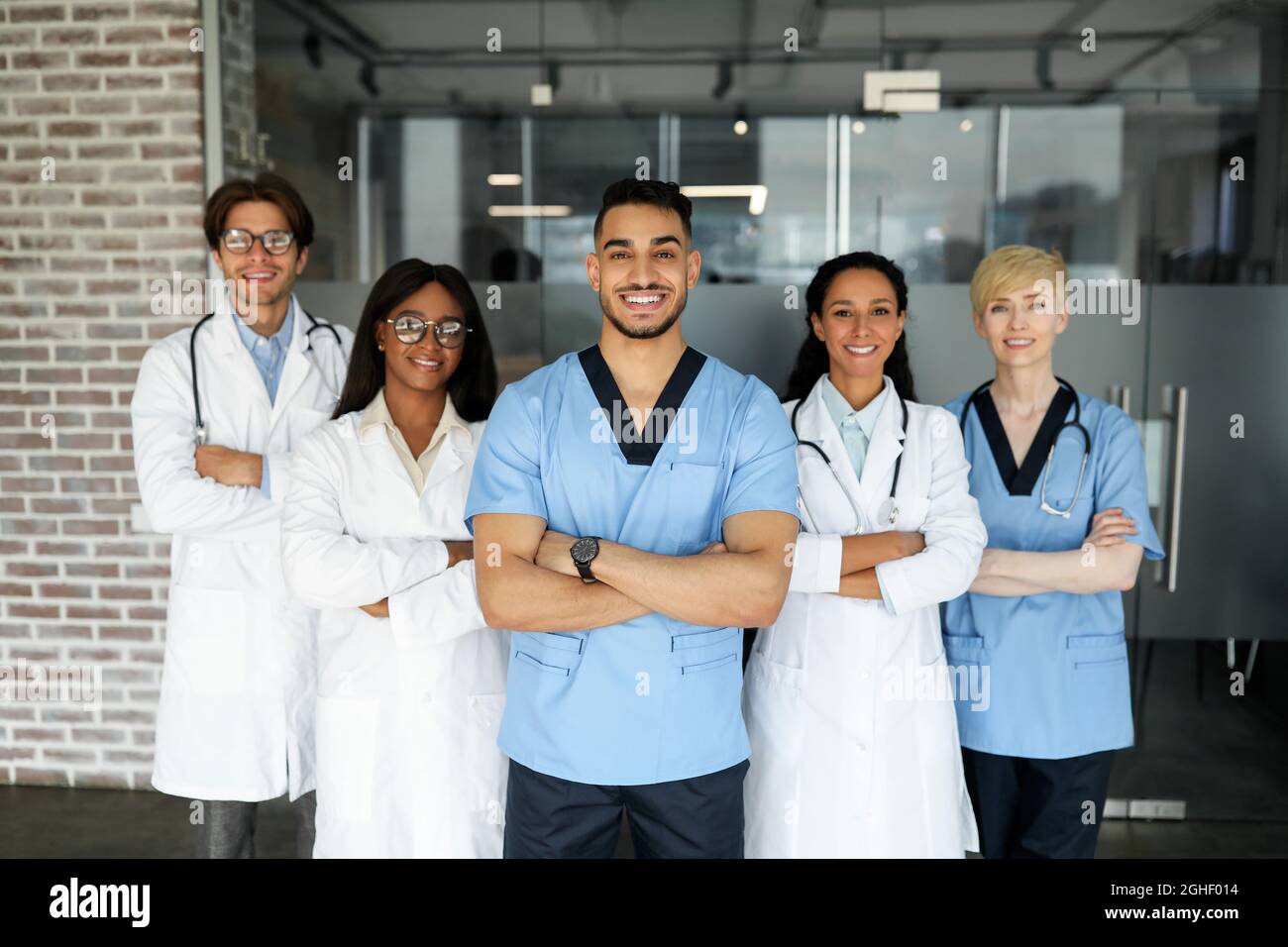 Équipe médicale internationale posant à la clinique tout en ayant l'esprit d'équipe Banque D'Images