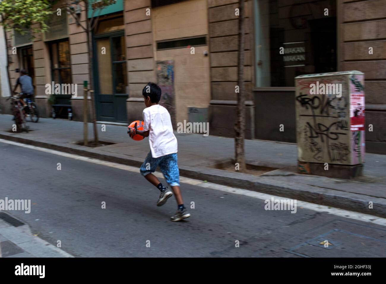 Barcelone, Catalogne, Espagne. Juillet 2018. Un garçon court dans la rue de Barcelone, Espagne. Banque D'Images