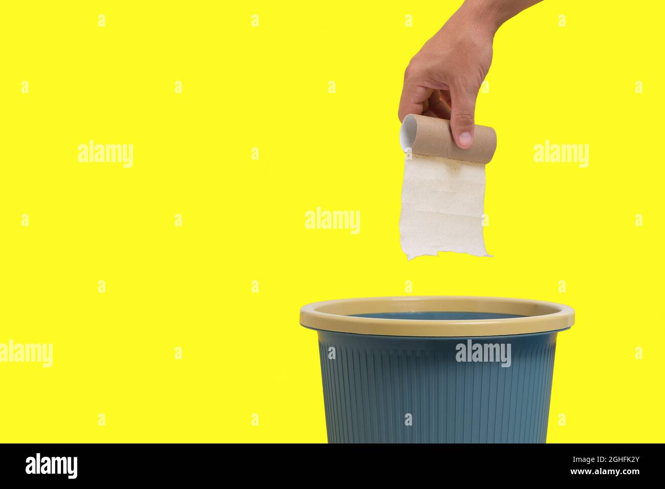 Le rouleau de papier toilette usagé et fini est jeté dans les ordures sur  fond jaune Photo Stock - Alamy