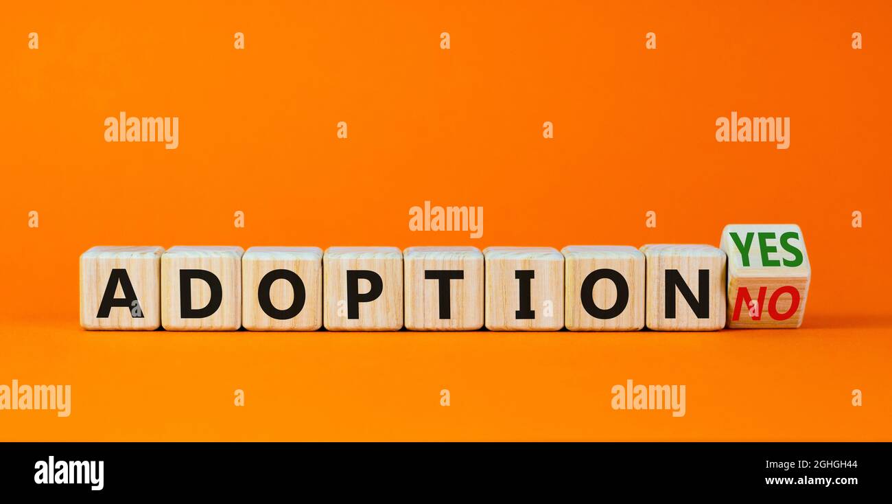 Symbole d'adoption. A transformé un cube en bois et a changé les mots « adoption non » en « adoption oui ». Magnifique arrière-plan orange. Concept d'entreprise et d'adoption, c Banque D'Images