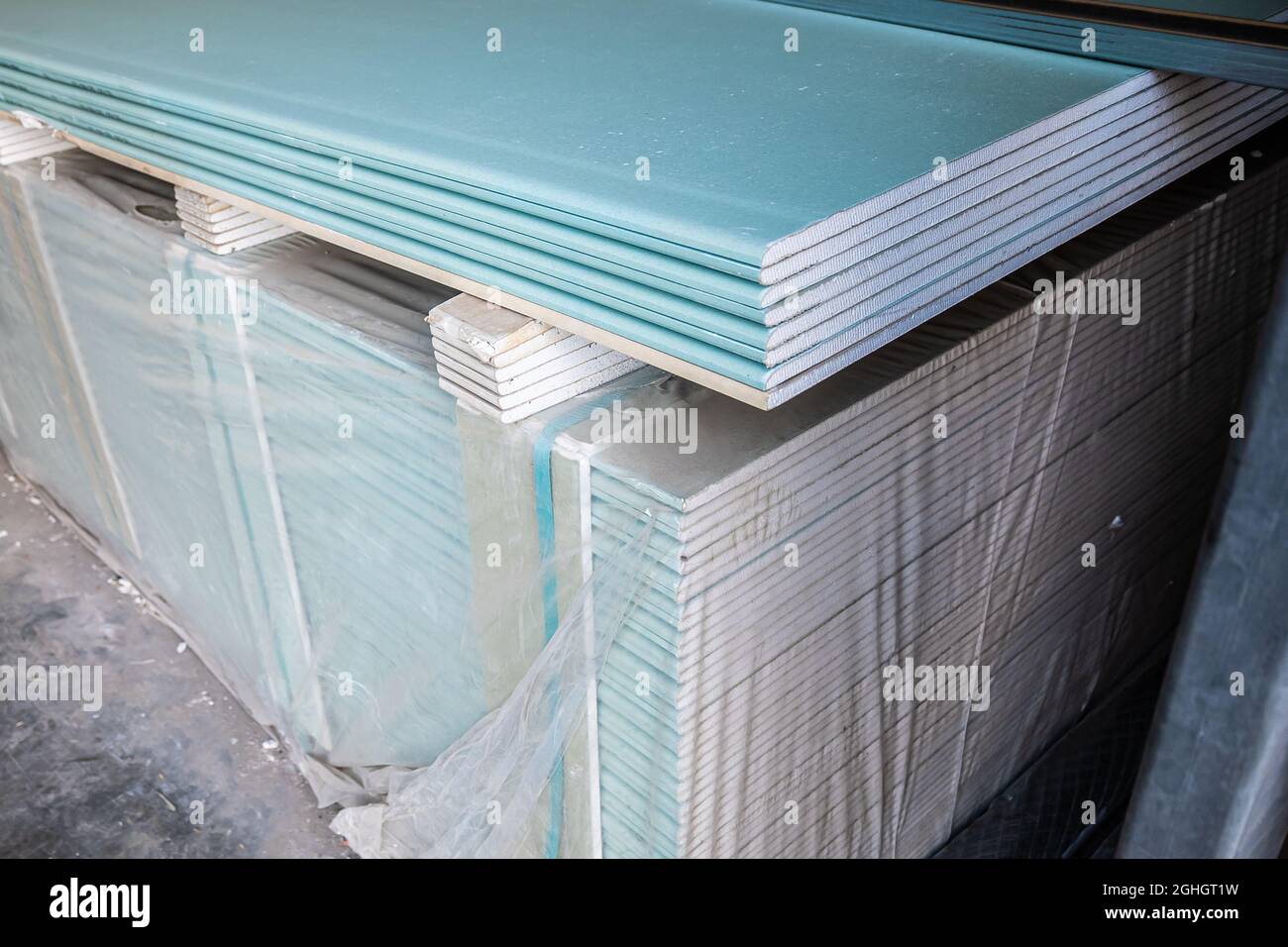 Feuilles de cloisons sèches dans une pile dans un entrepôt de matériaux de construction. Plaques de plâtre en stock Banque D'Images