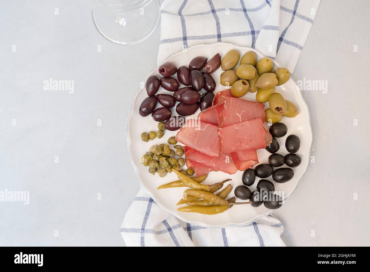 Plateau antipasti avec salami Baturma, cornichons, câpres et olives sur fond neutre, vue du dessus avec espace pour les copies Banque D'Images