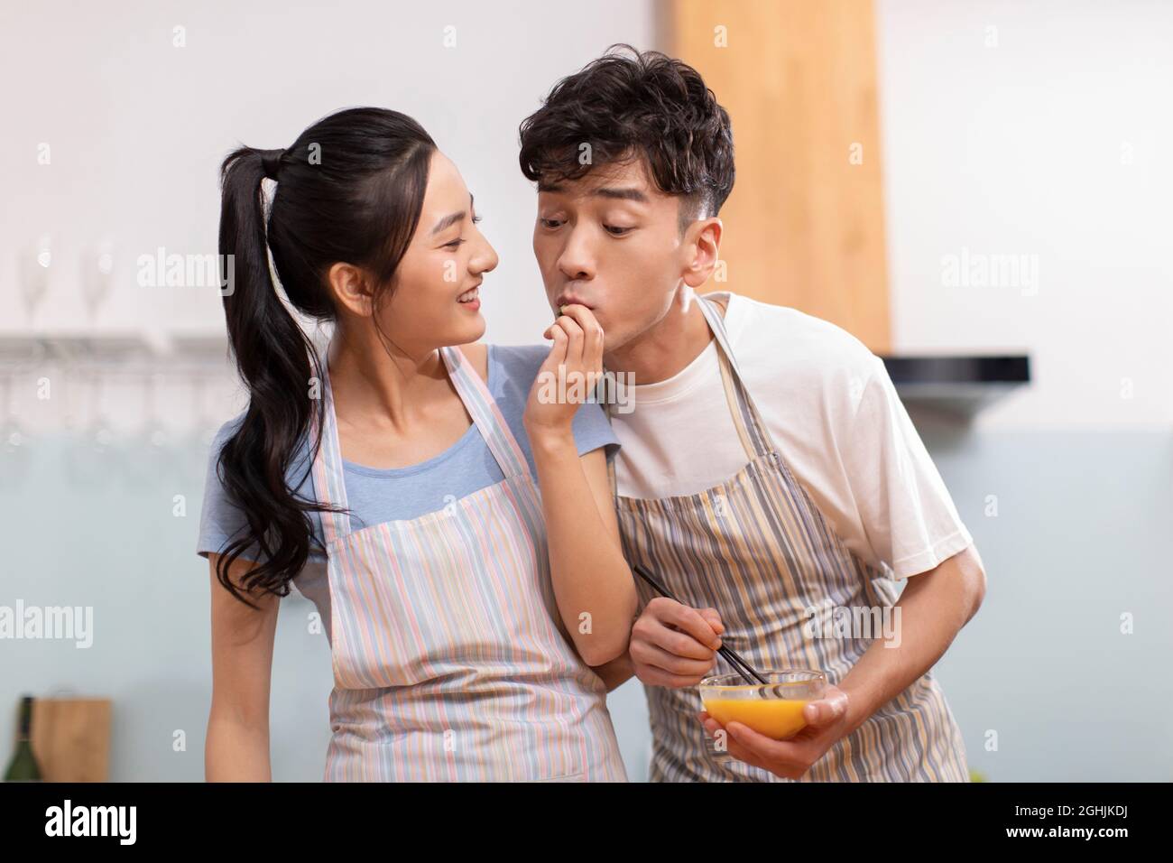 Happy young couple cooking in kitchen Banque D'Images