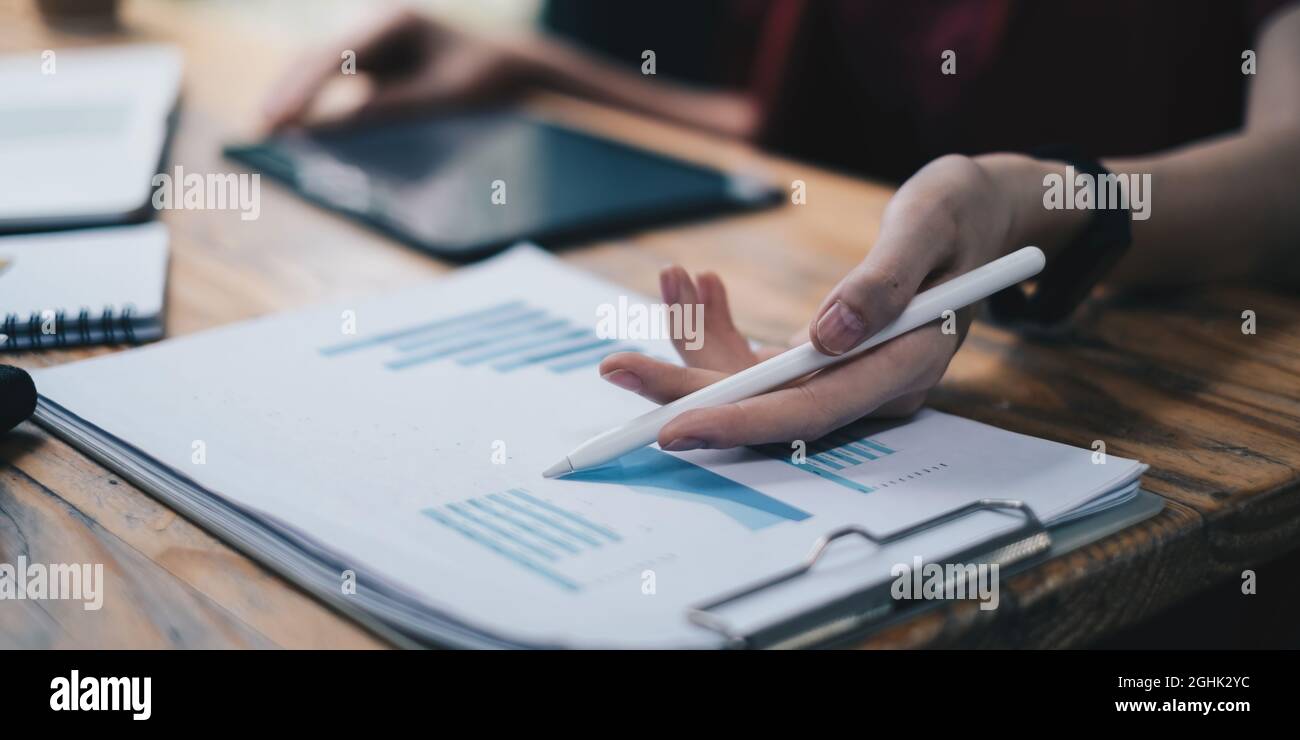 Femme d'affaires faire comptabilité financière bourse analyse des graphiques sur la paperasserie dans le bureau Banque D'Images